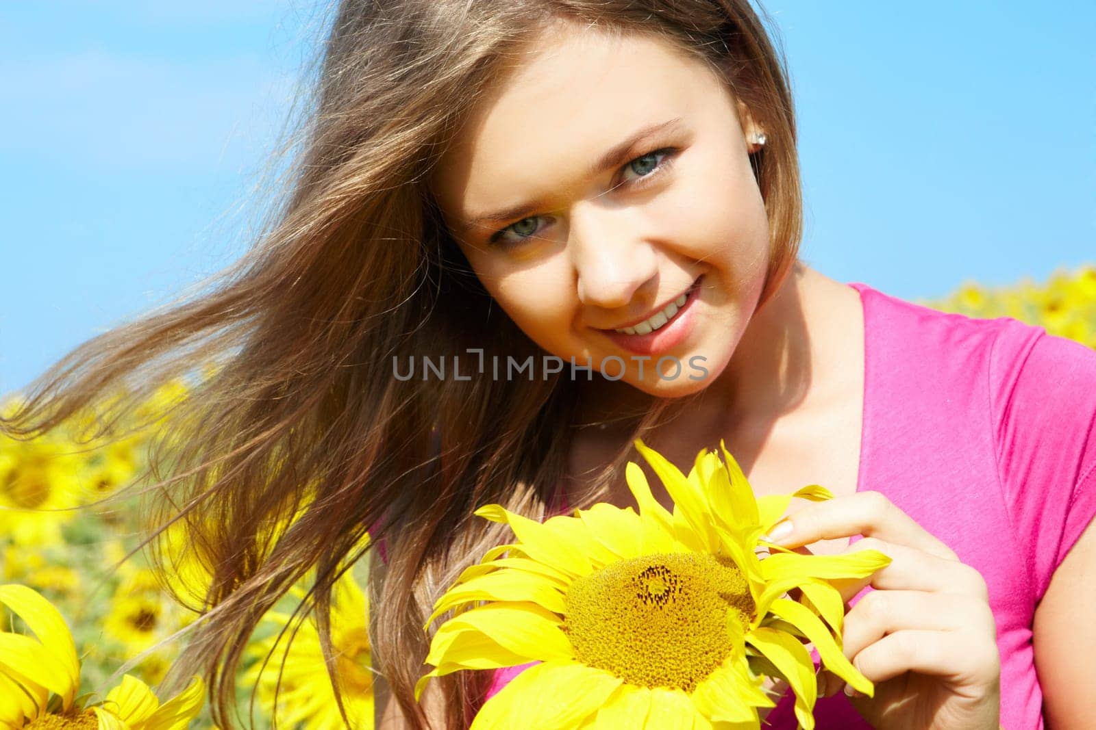 Photo of pretty girl with sunflower looking at camera on sunny day