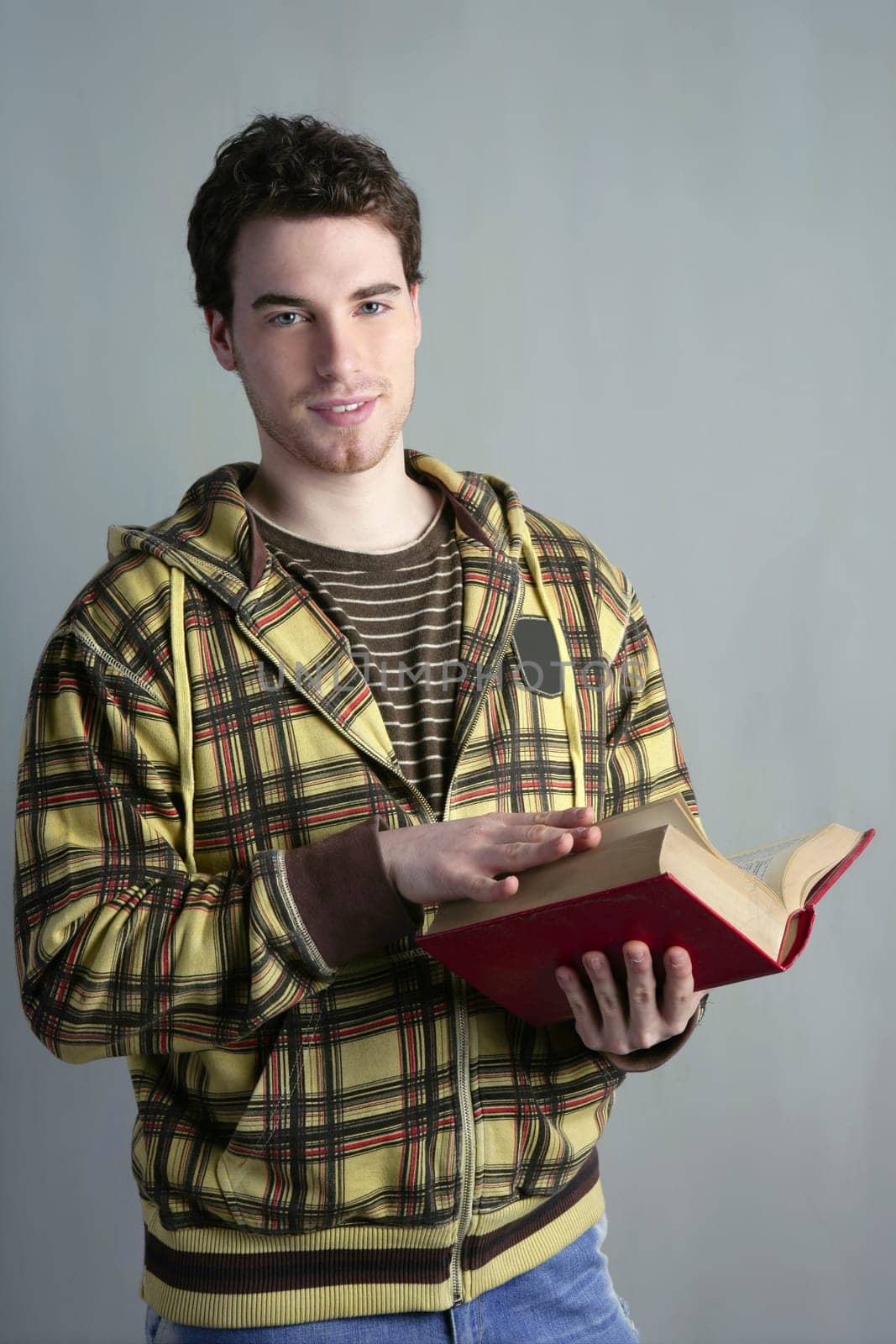 young student boy with open book in hands yellow clothes