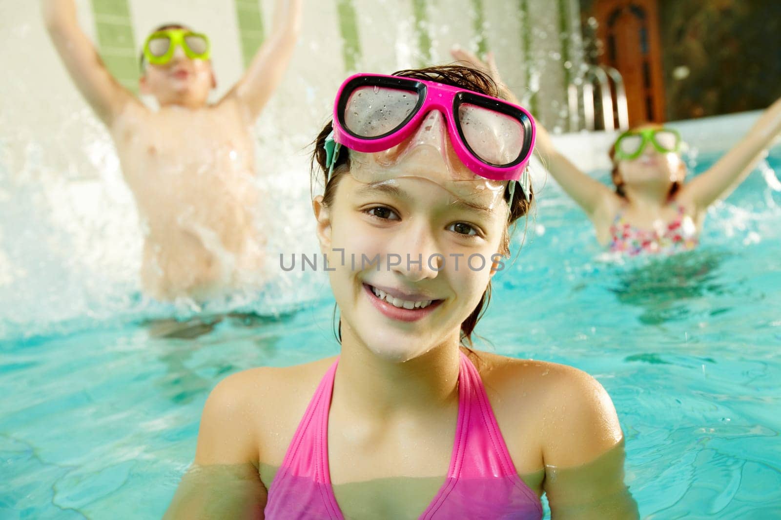 Photo of happy girl in pool with her friends having fun on backround