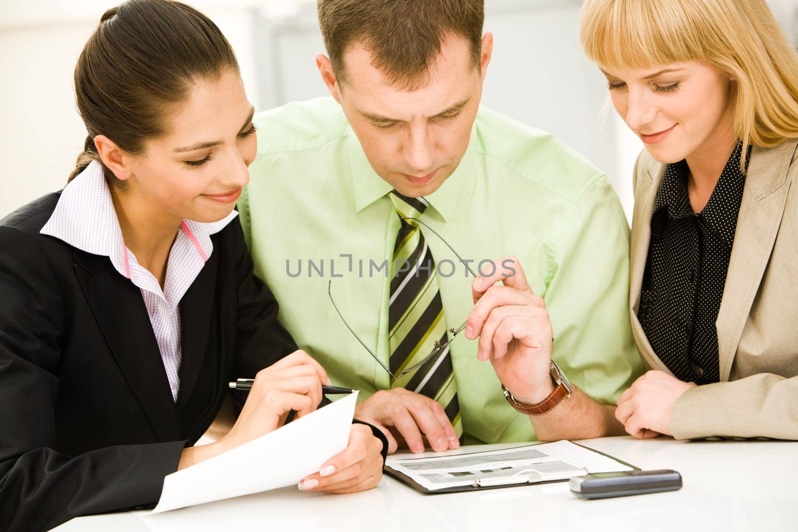 Portrait of successful business partners sitting in the office and looking at new business plan with smiles