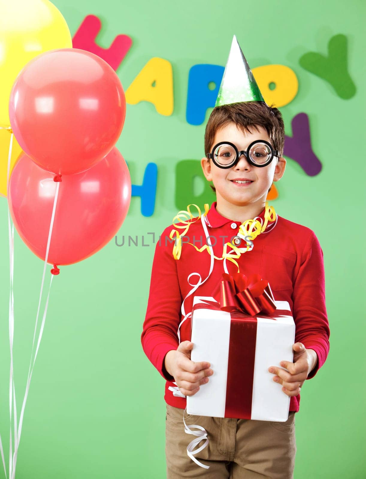 Portrait of happy lad in funny eyeglasses on birthday party with giftbox