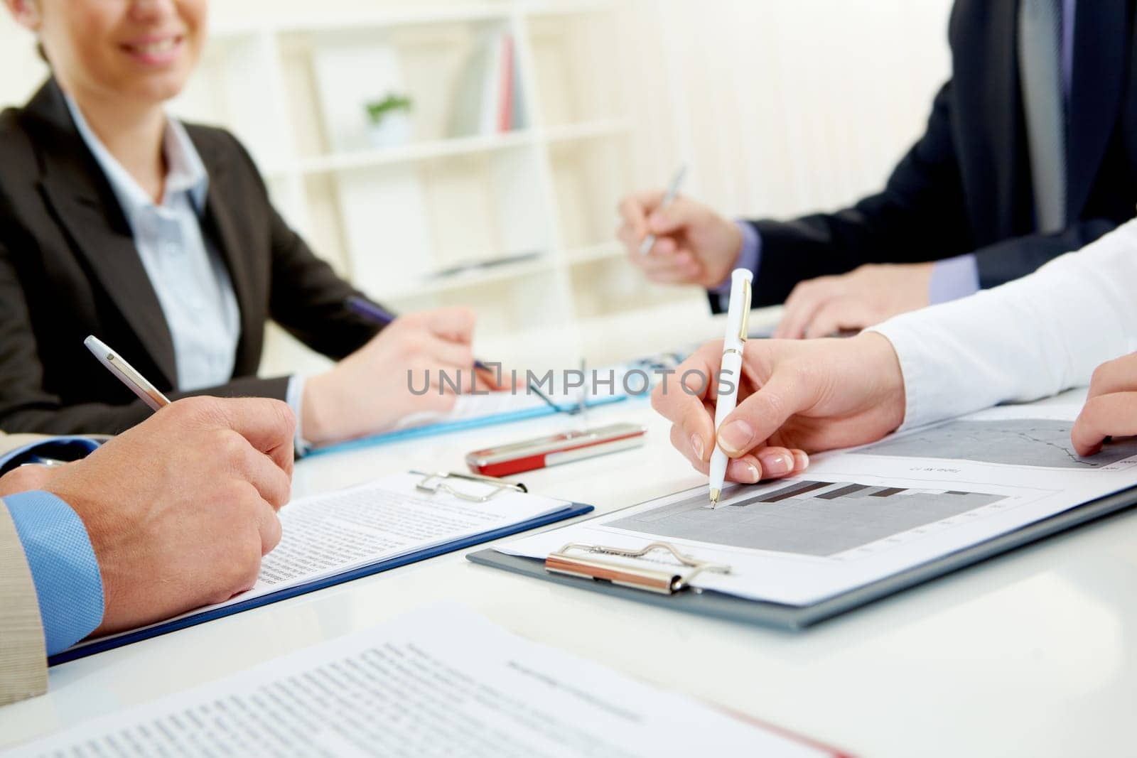 Close-up of business person hand over document in working environment
