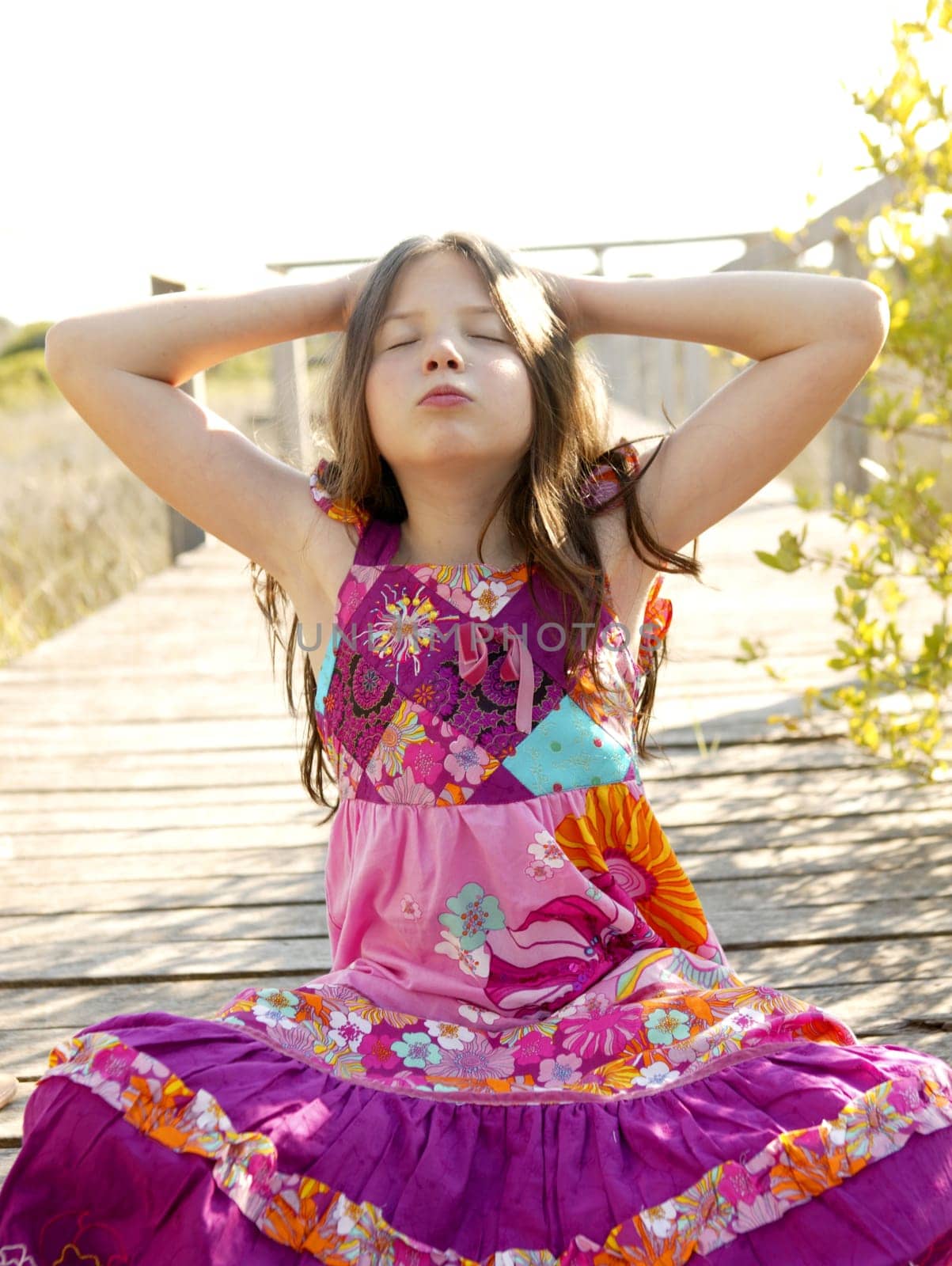 Hippy purple dress teen girl relaxed outdoors, sitting over the park wood