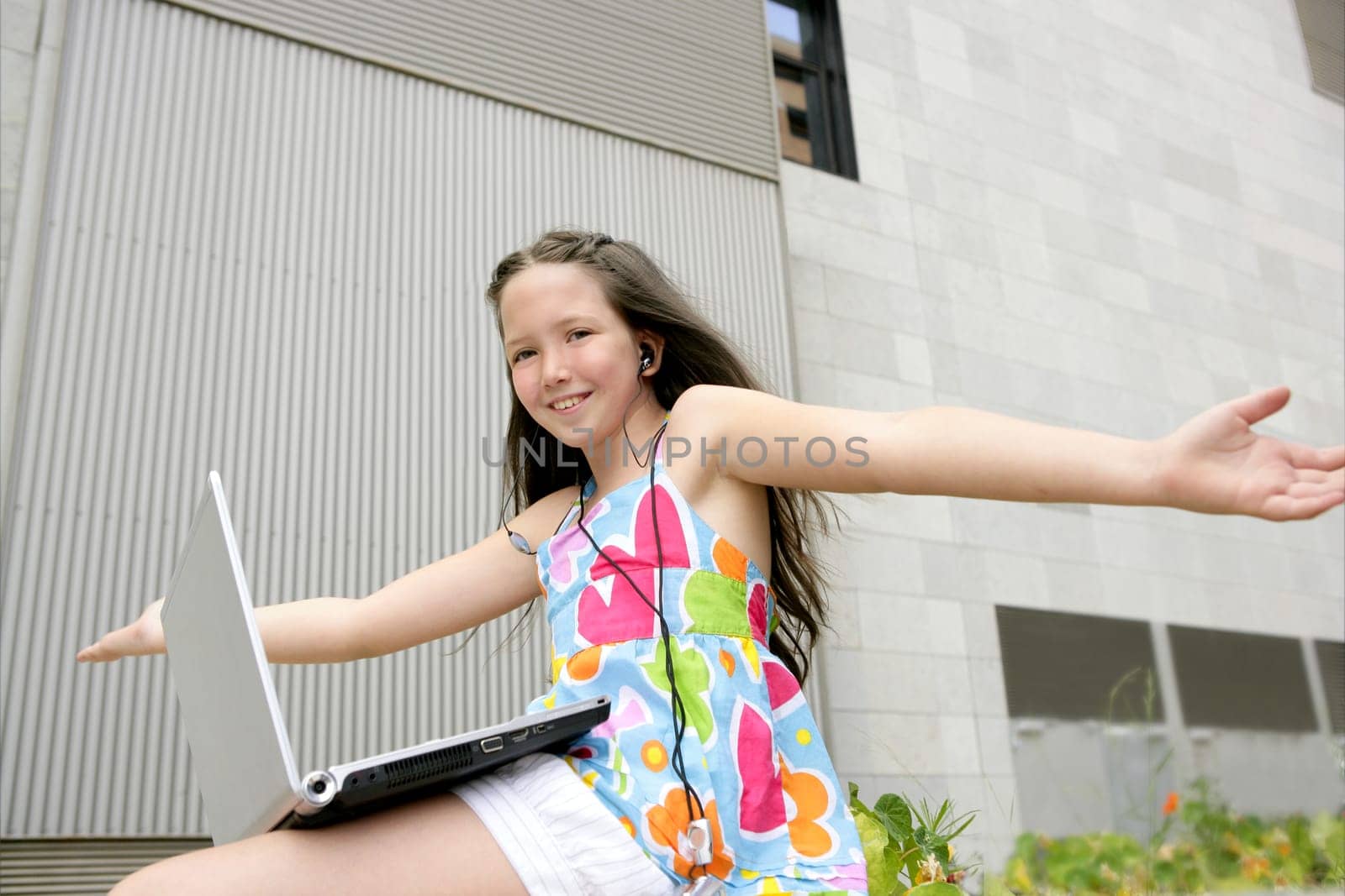Beautiful brunette little girl teen expression with laptop city outdoor