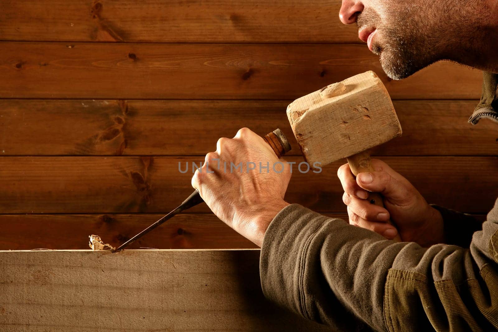 gouge wood chisel carpenter tool hammer in hand working wooden background