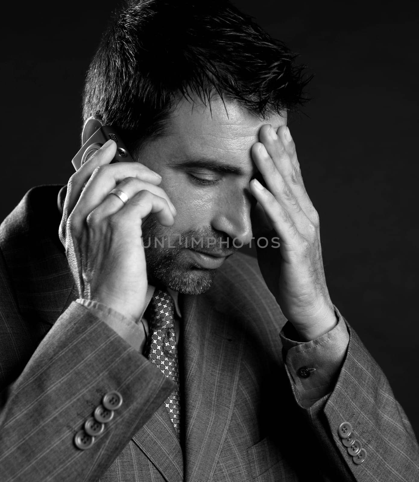 businessman stress with headache and mobile phone over black