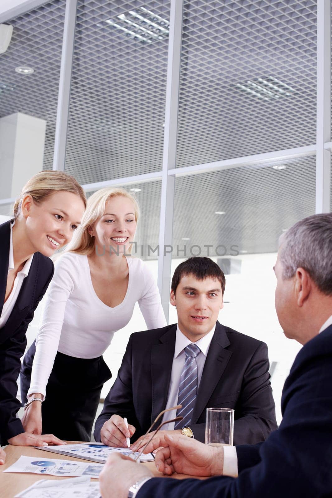 Three businesspeople looking at their boss