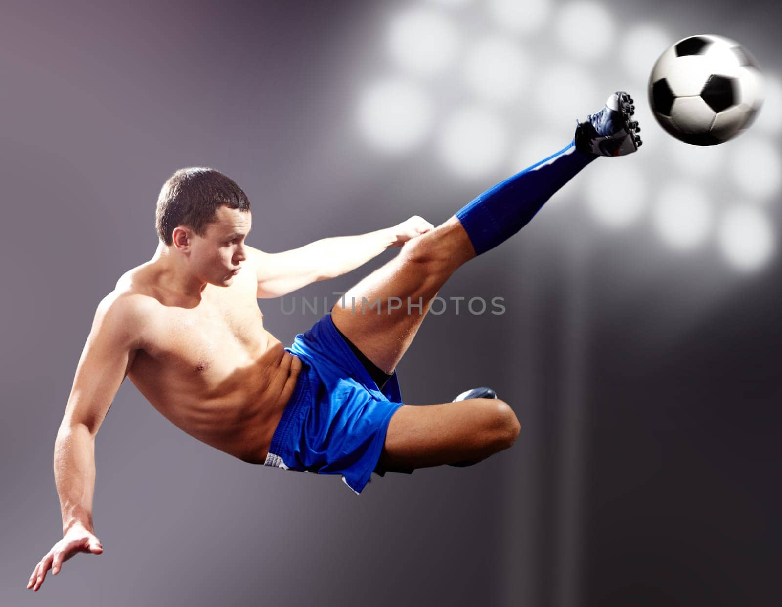 Professional footballer kicking soccer ball