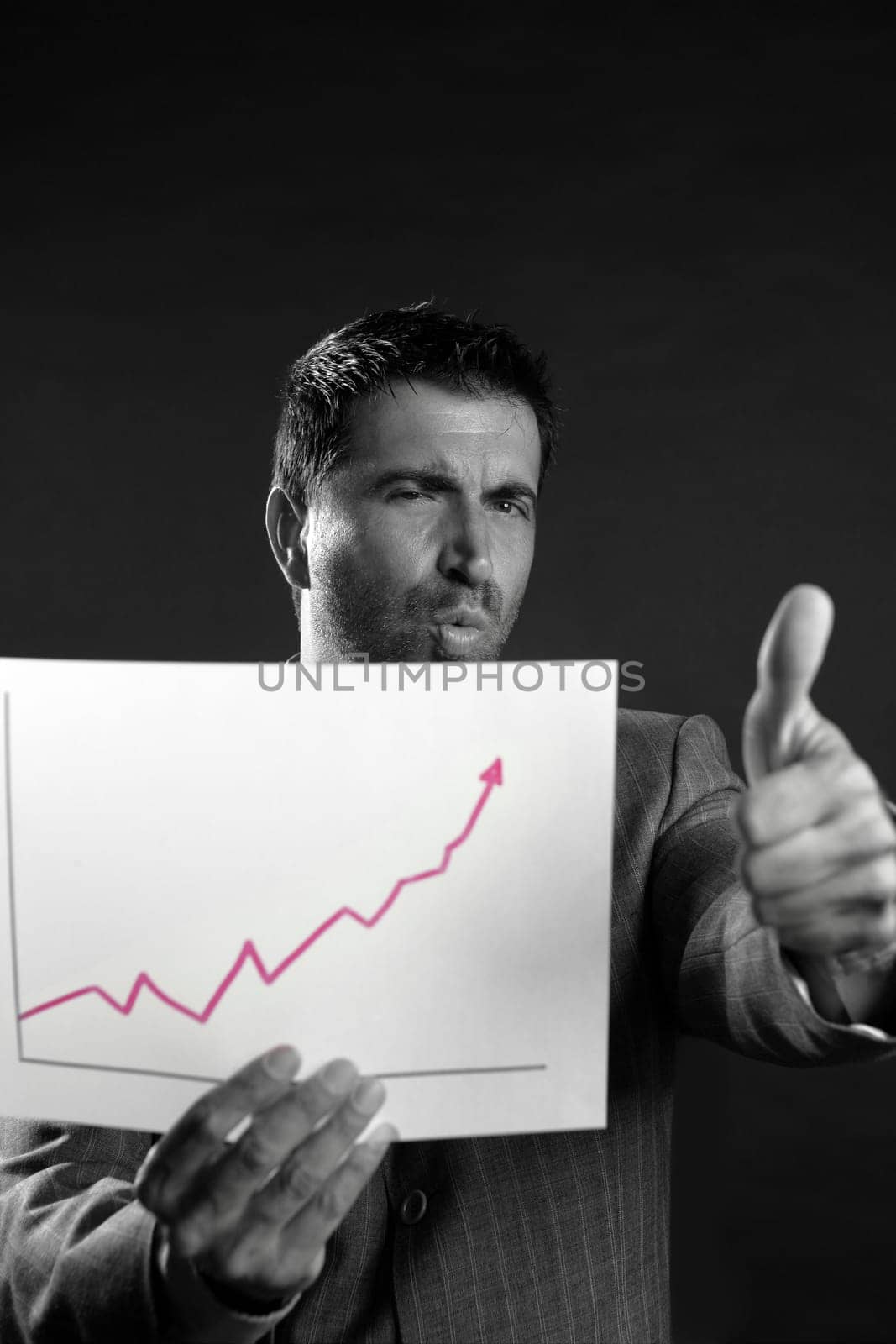 Businessman with good sales reports graph, studio shot black background