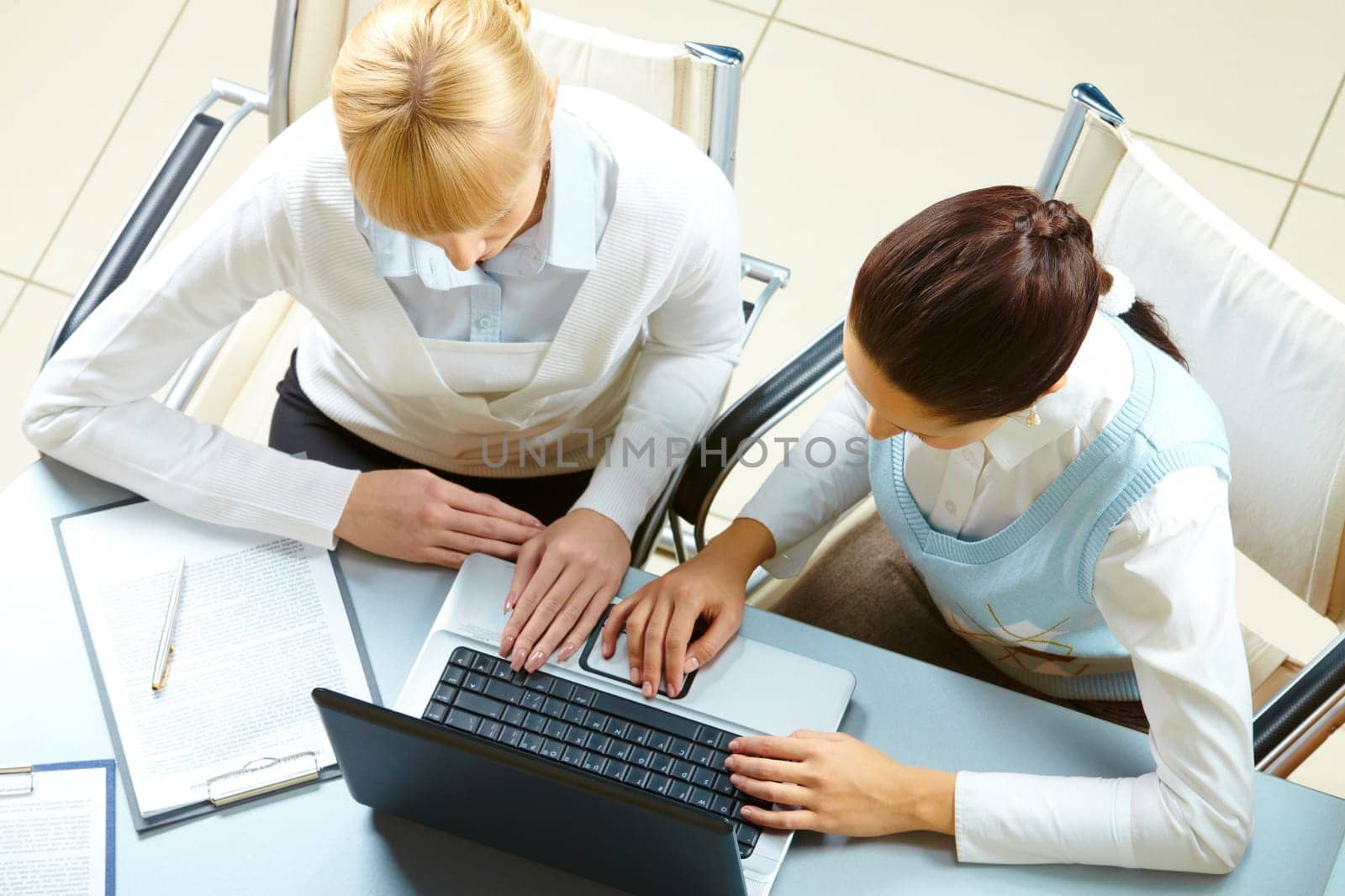 Above view of two businesswomen typing on a laptop