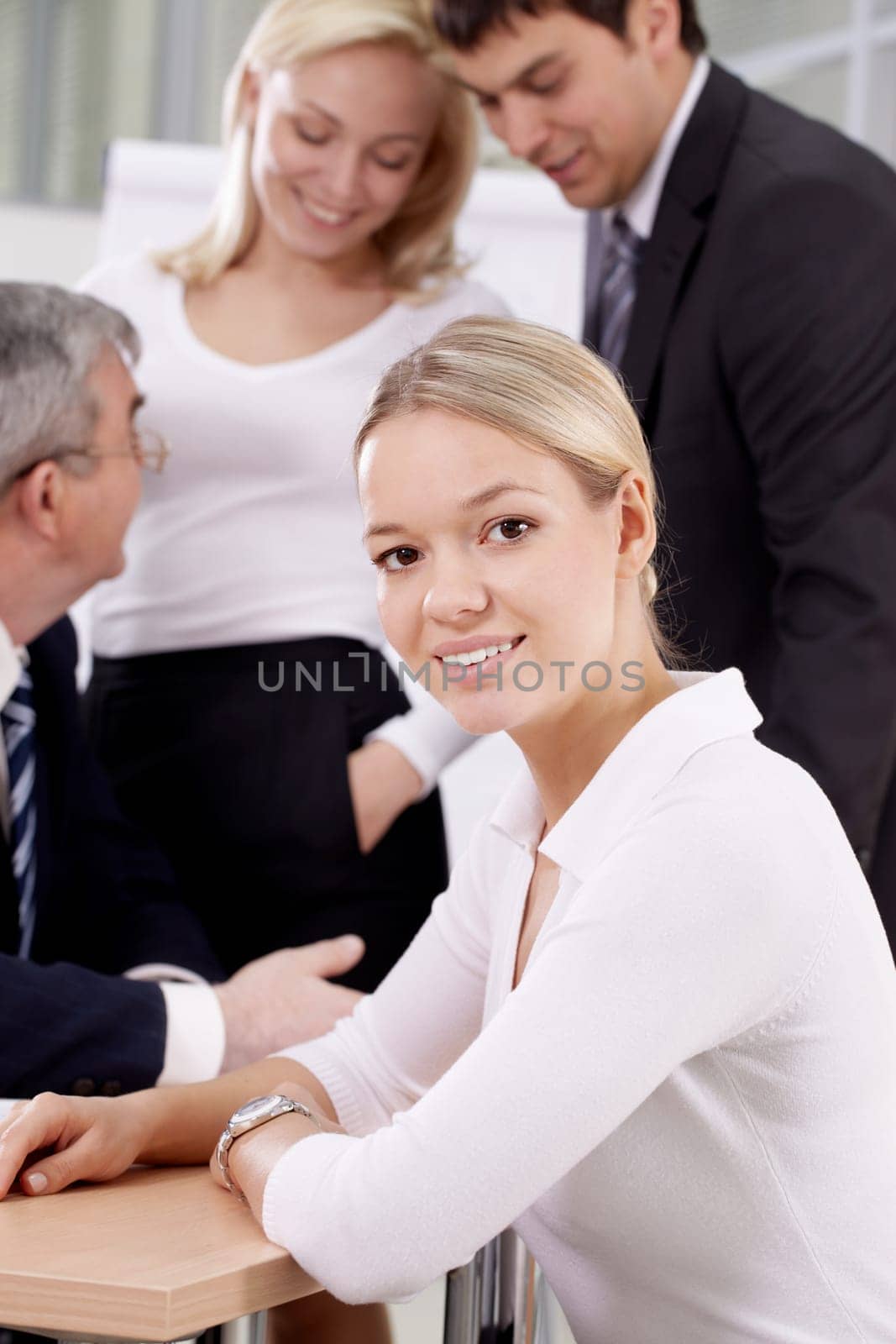 Portrait of a young woman against her colleagues