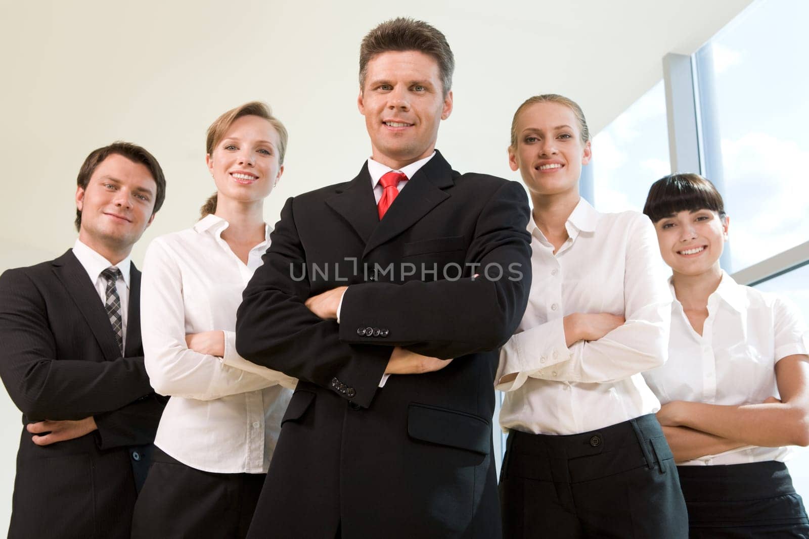 Several business partners looking at camera with successful man in front
