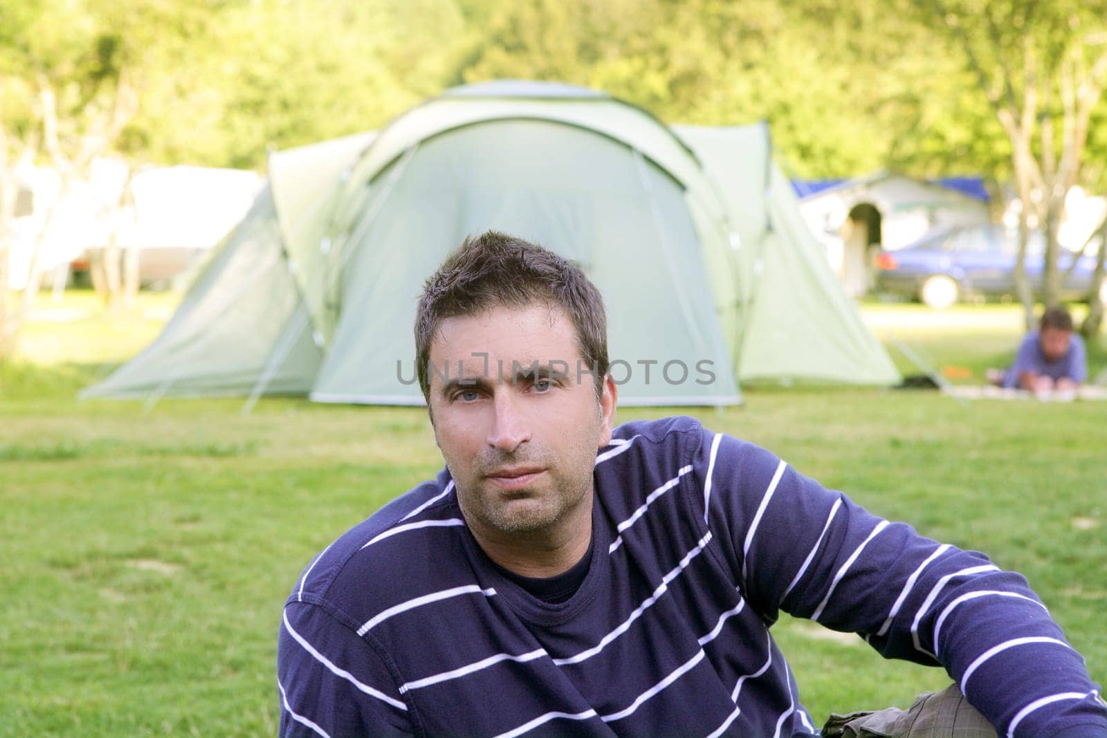 Caucassian man relaxed on the tent camping meadow