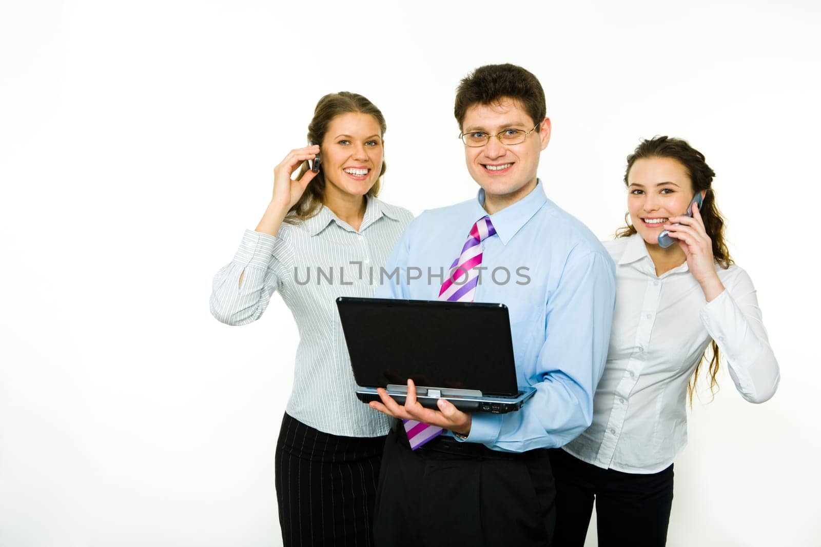 Portrait of confident man with two business women near by calling by phones