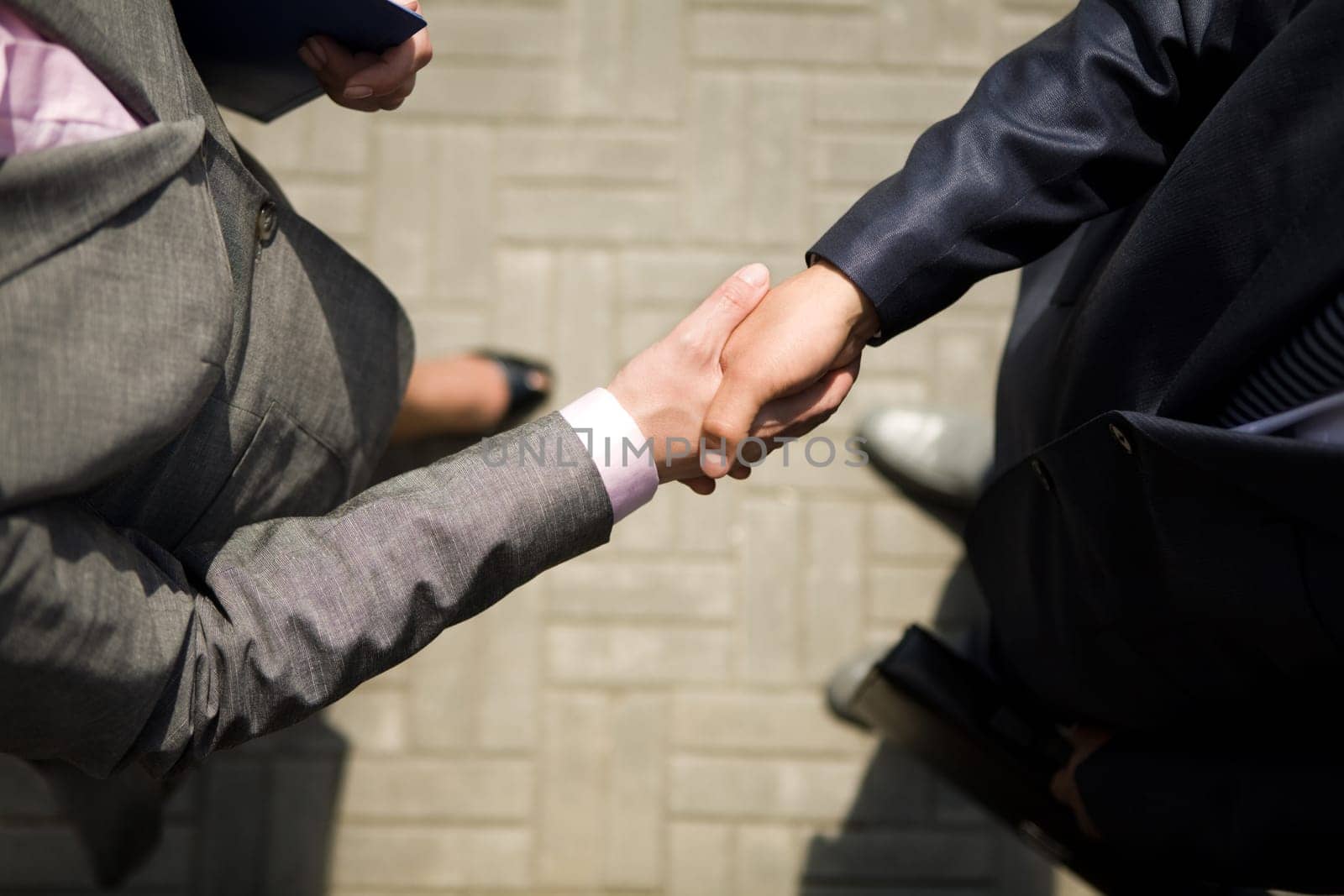 Above view of successful business partners handshaking after striking deal