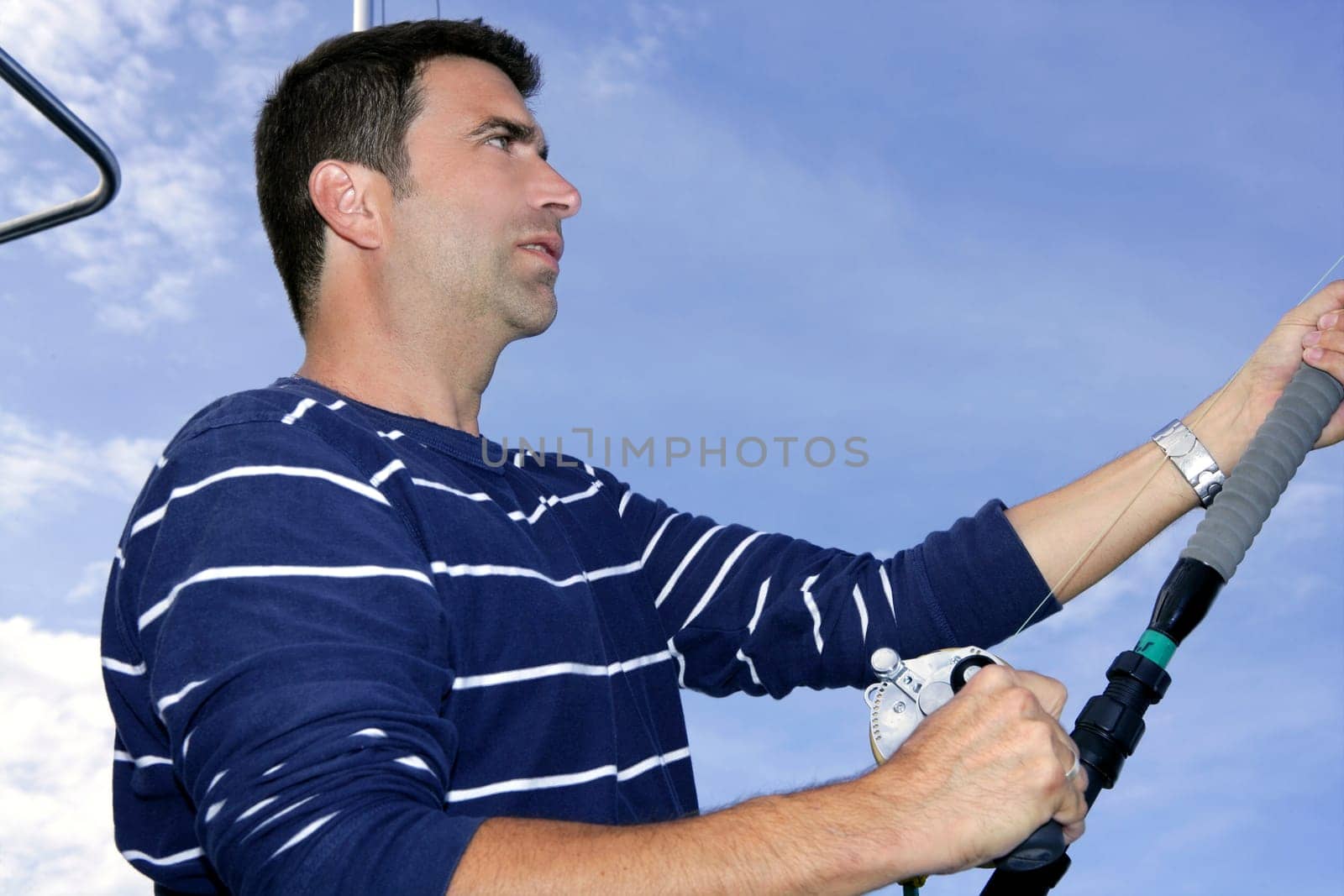 Angler fisherman trolling rod and reel fighting saltwater fish