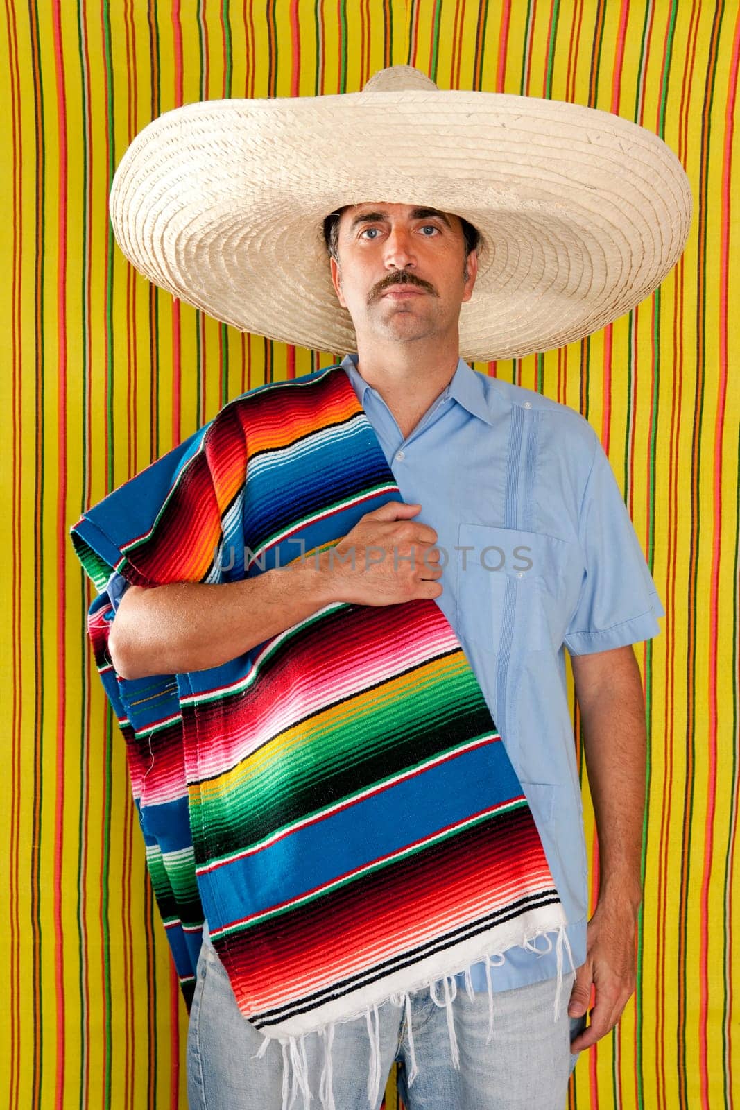 Mexican mustache man portrait with sombrero holding serape in shoulder