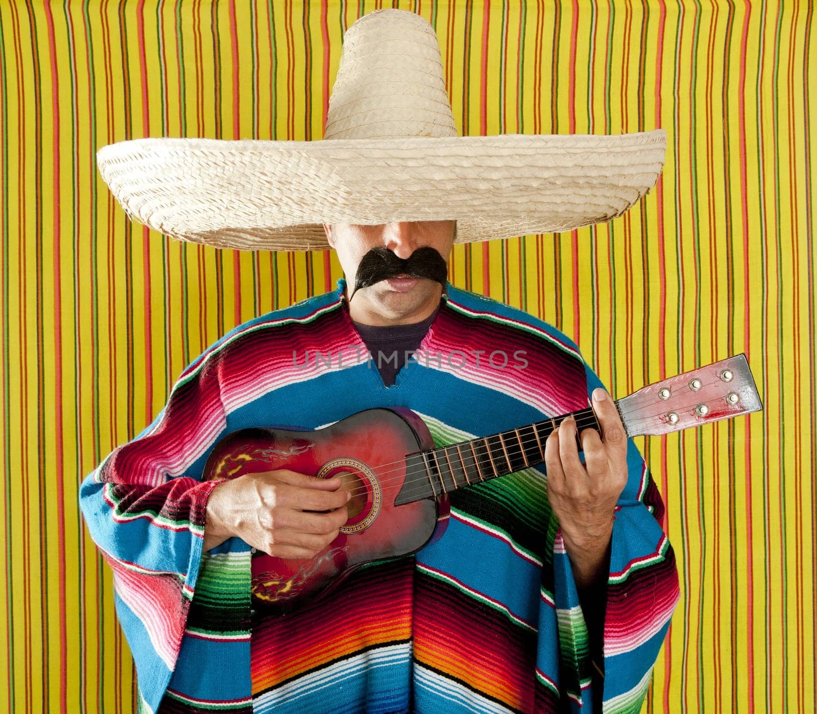Mexican man serape poncho sombrero playing guitar typical Mexico