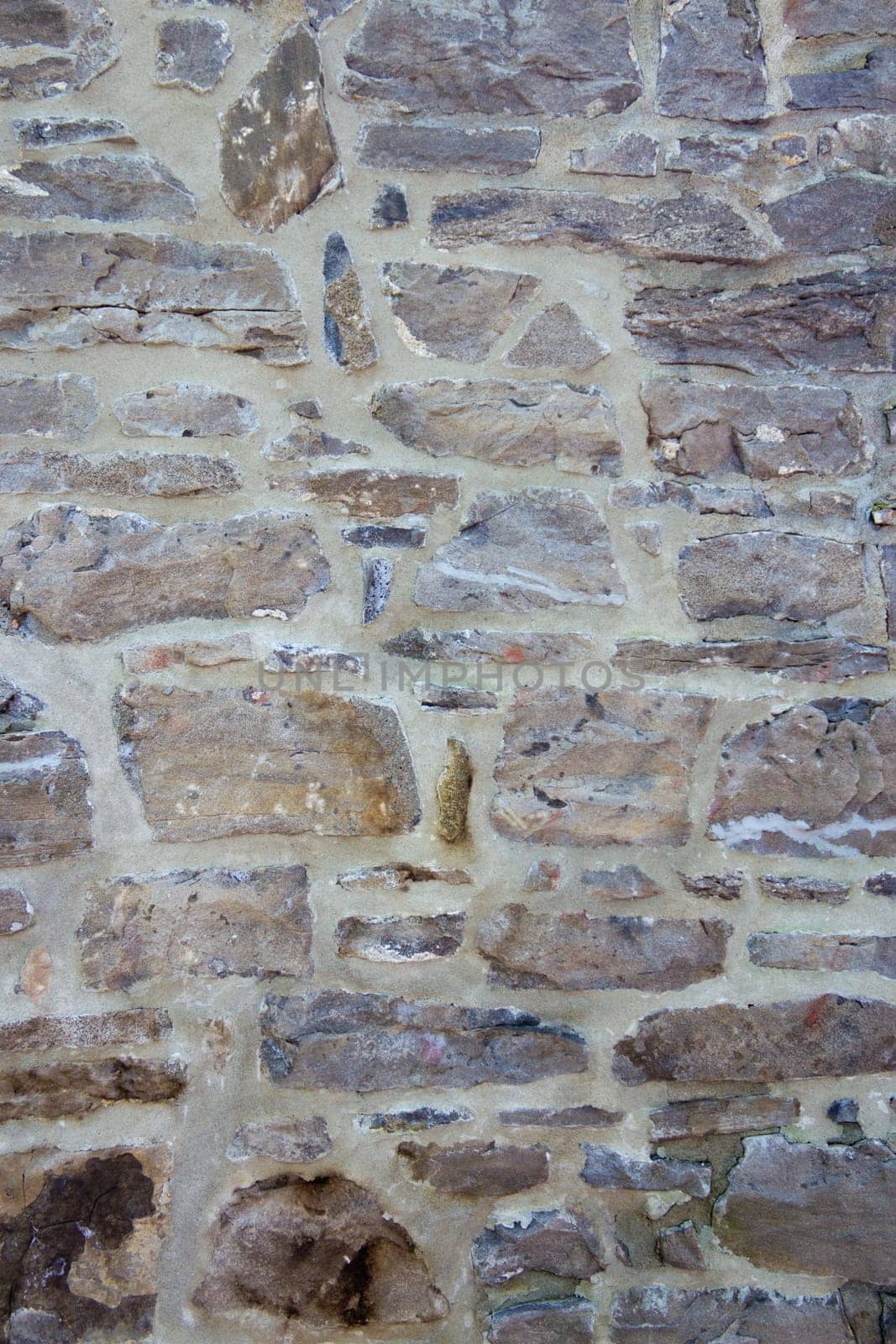 Old wall with irregular pattern of stone - background.