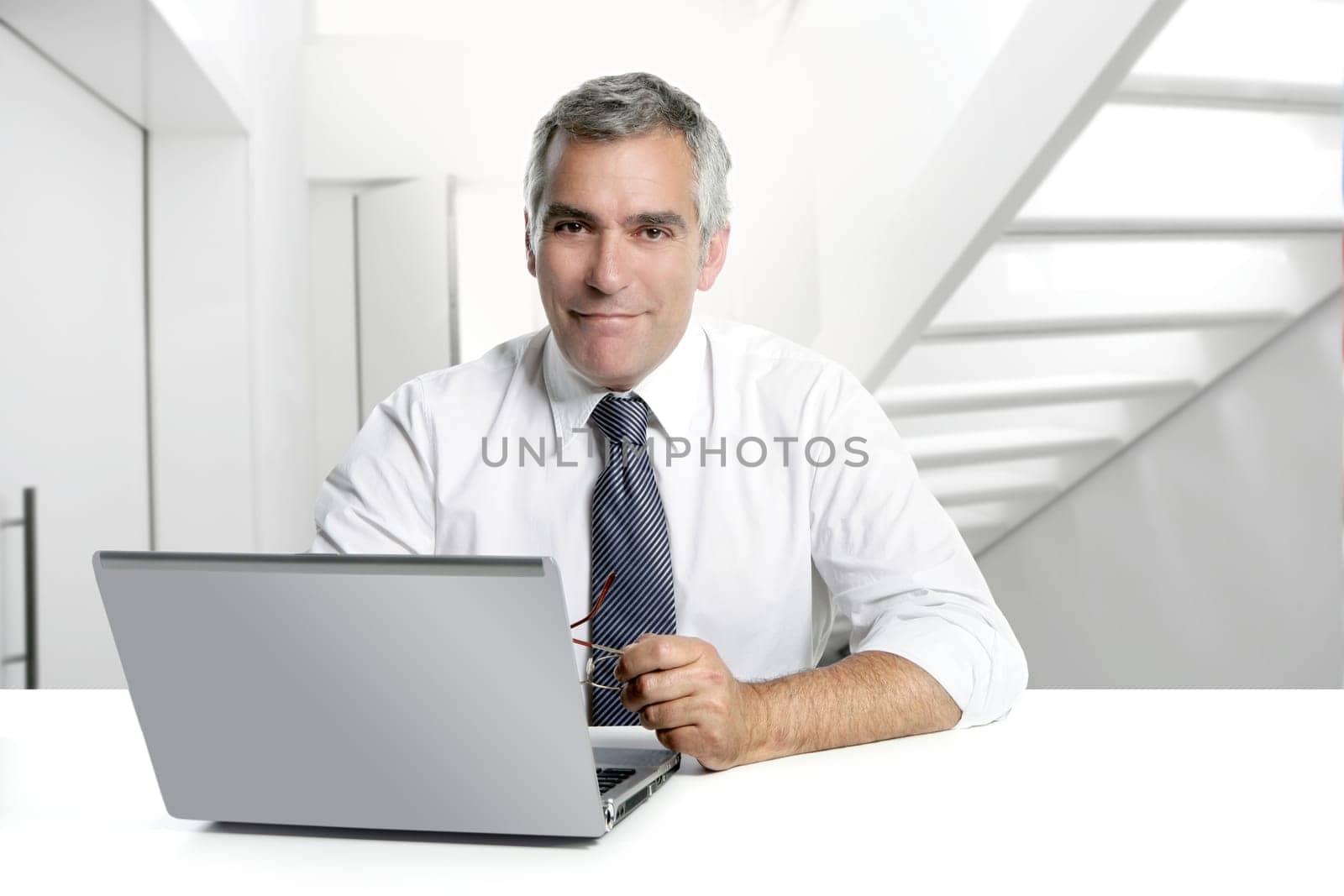 businessman senior gray hair working laptop interior modern white office