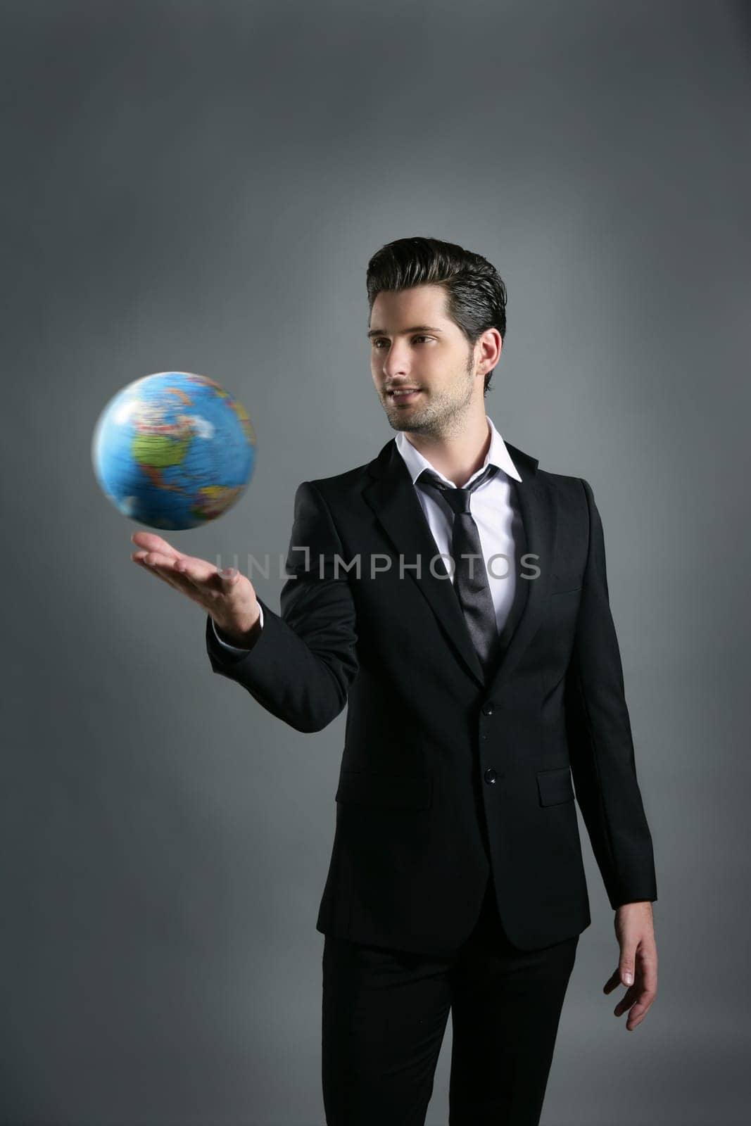 World globe map sphere in businessman hand over dark gray background