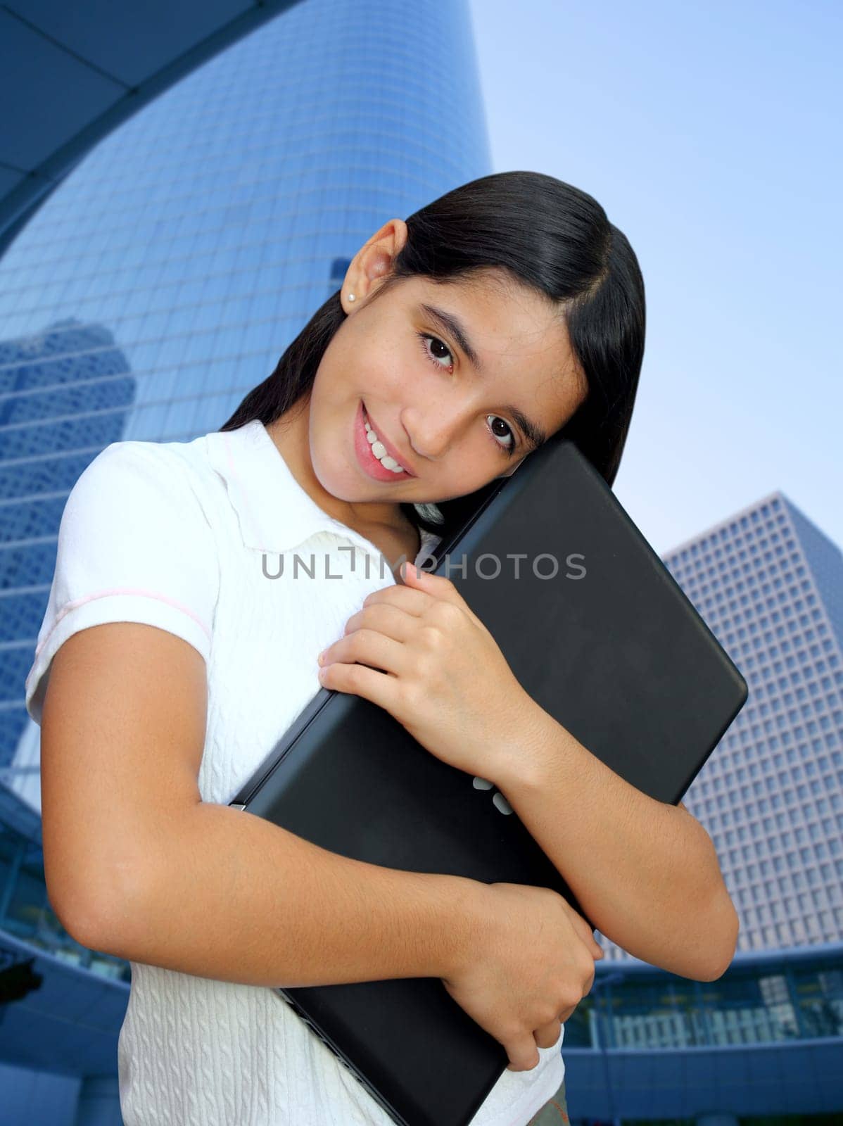 latin teenager brunette student hug laptop modern city buildings