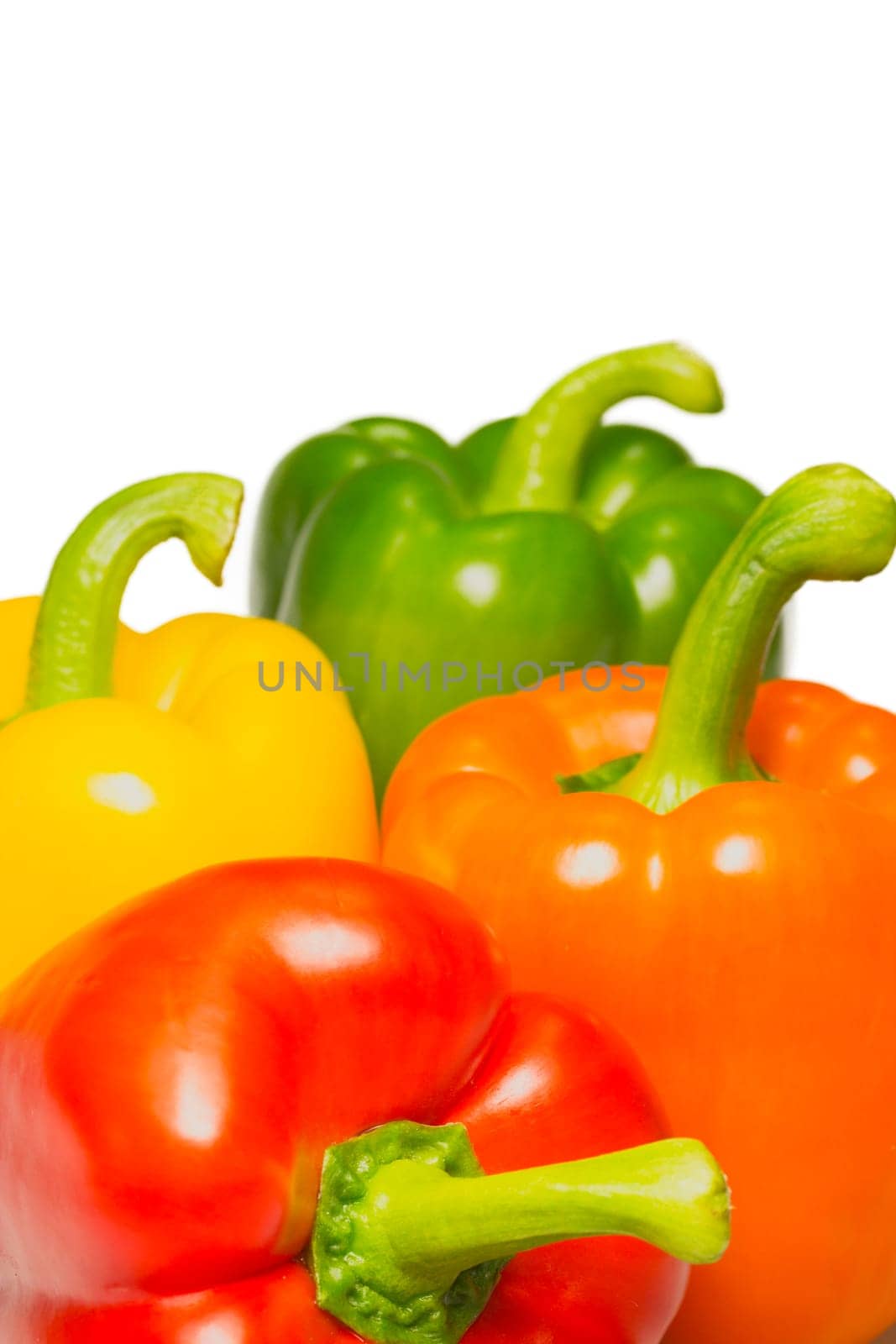 Orange, red, yellow and green peppers on a white background.