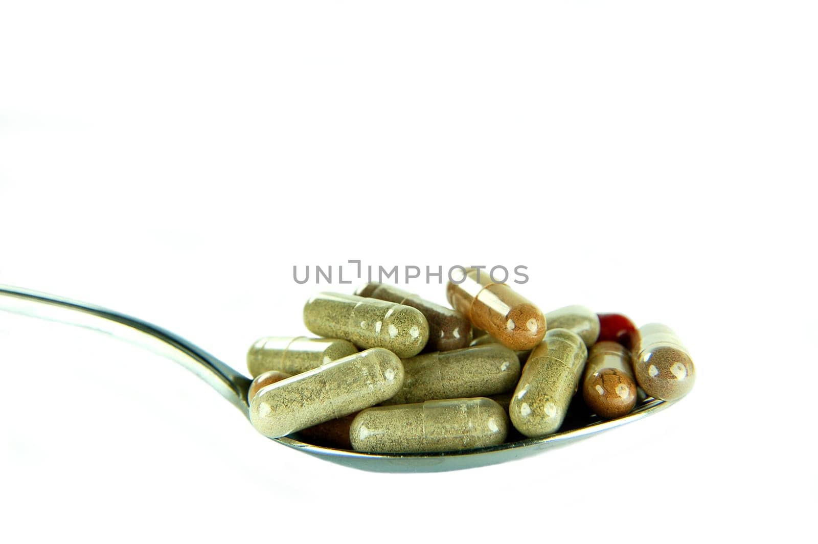 Herbal capsules on a spoon