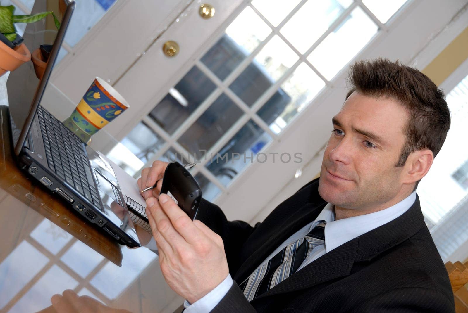 businessman at his dining room table with PDA