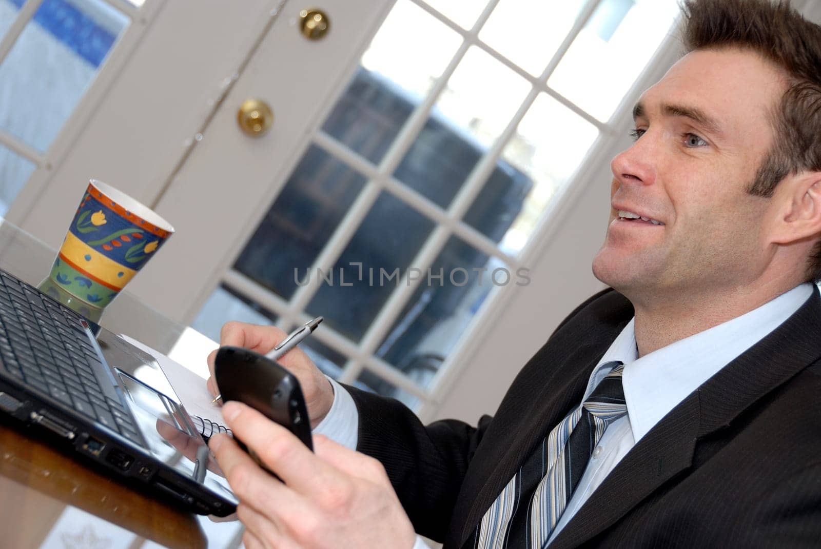 man in a black suit and tie chatting