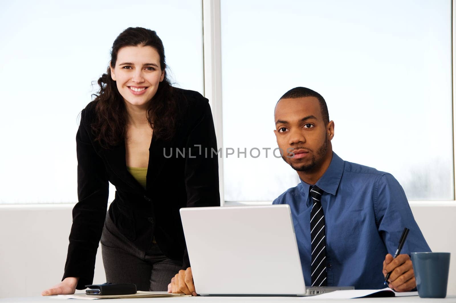 two business associates with a grey laptop
