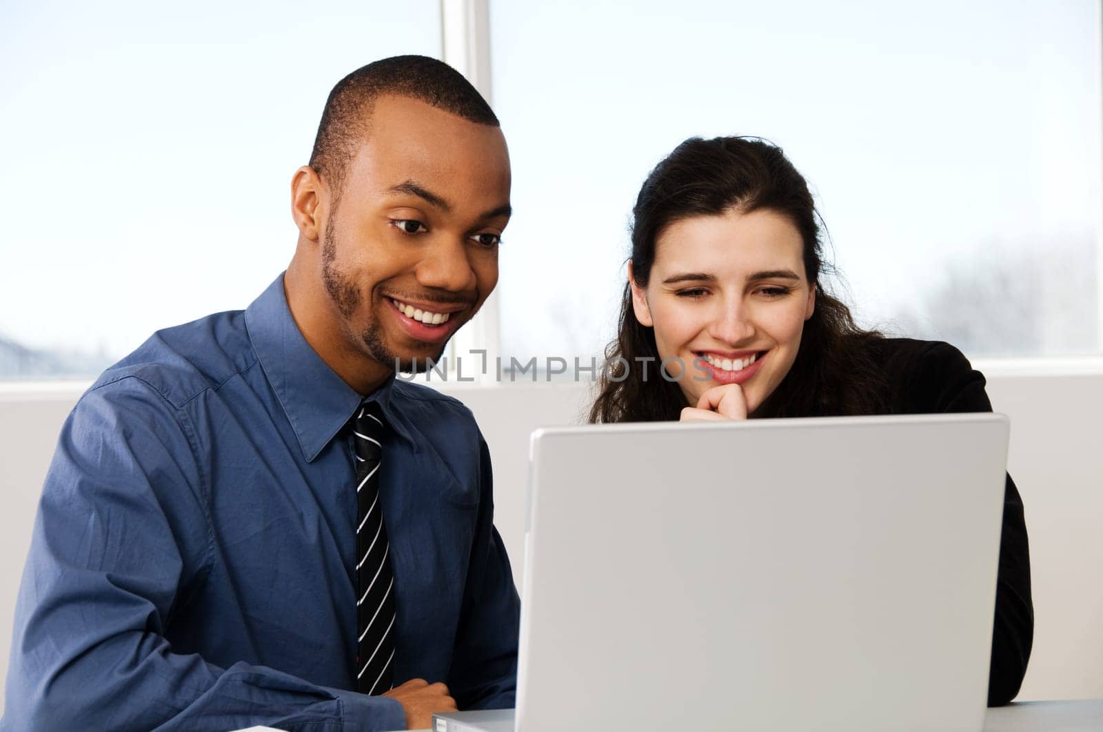 two business associates with a grey laptop