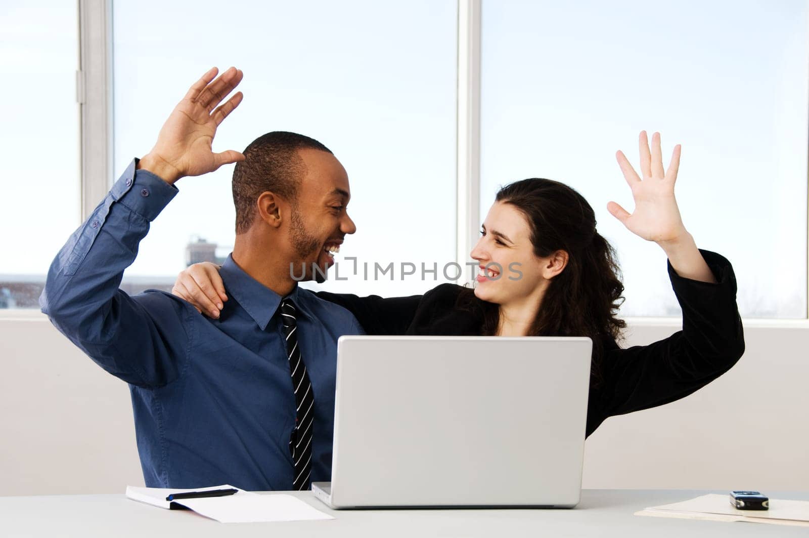 two business associates with a grey laptop