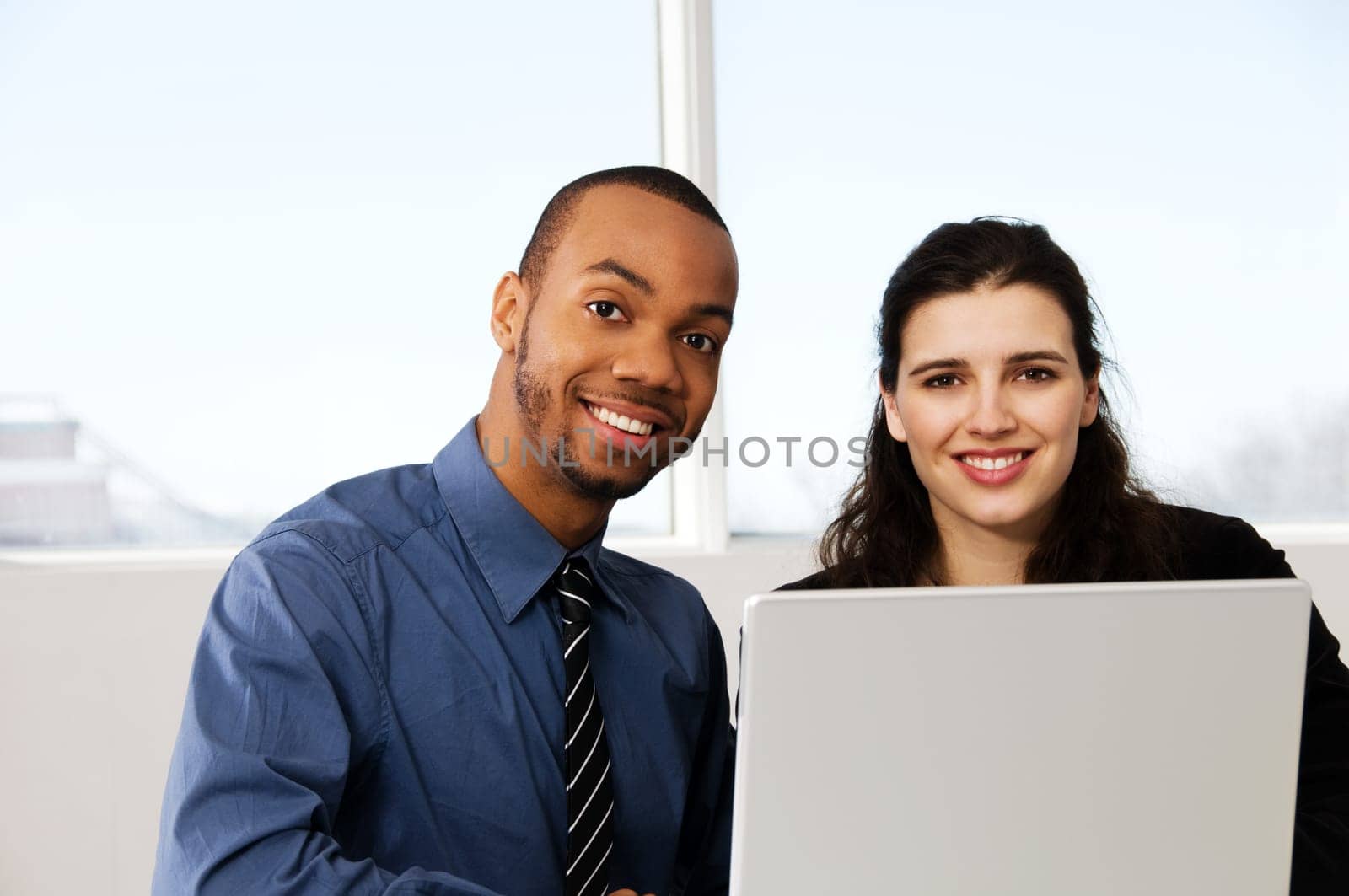 two business associates with a grey laptop