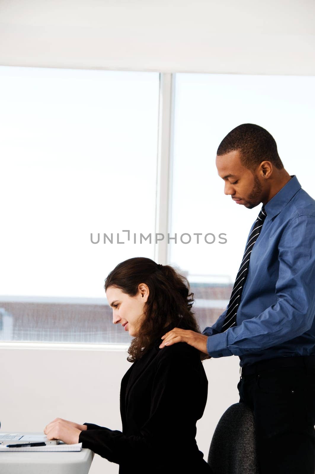 two business associates with a grey laptop