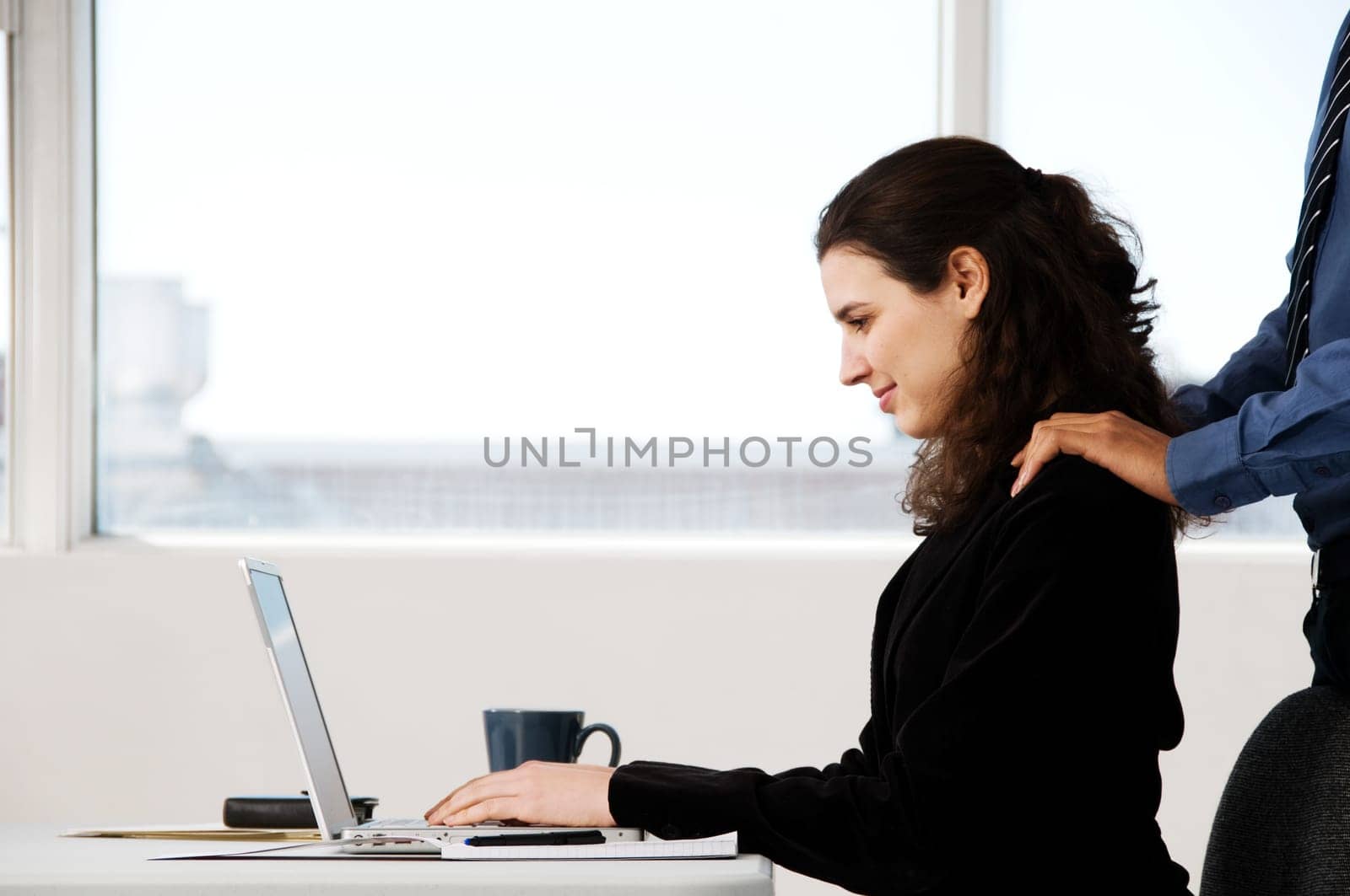 two business associates with a grey laptop