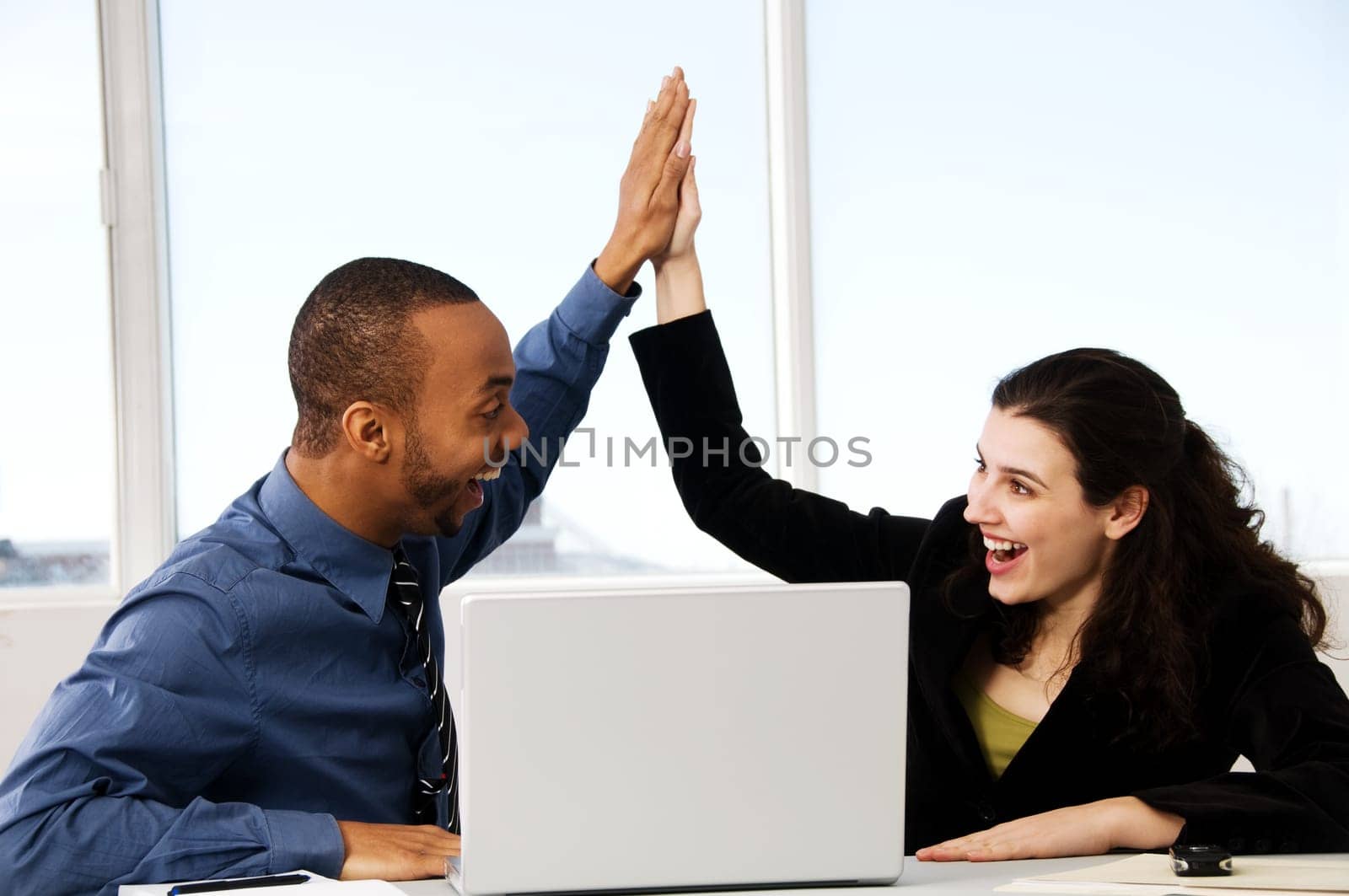 two business associates with a grey laptop