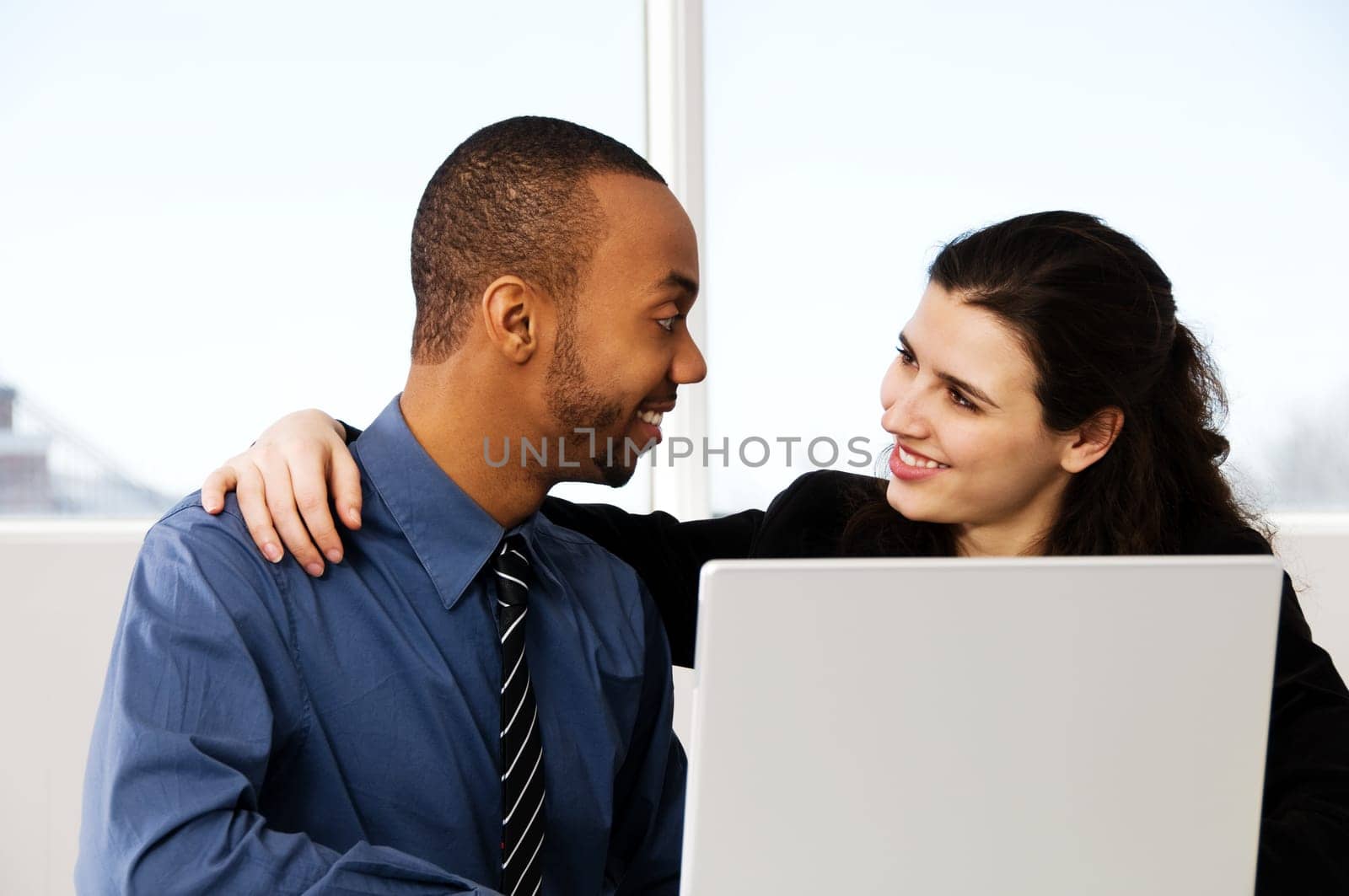 two business associates with a grey laptop