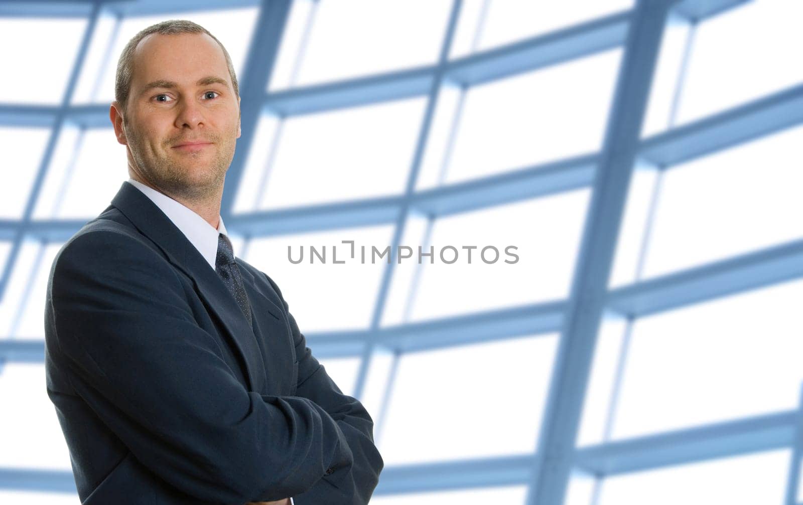 business man with his arms crossed with windows