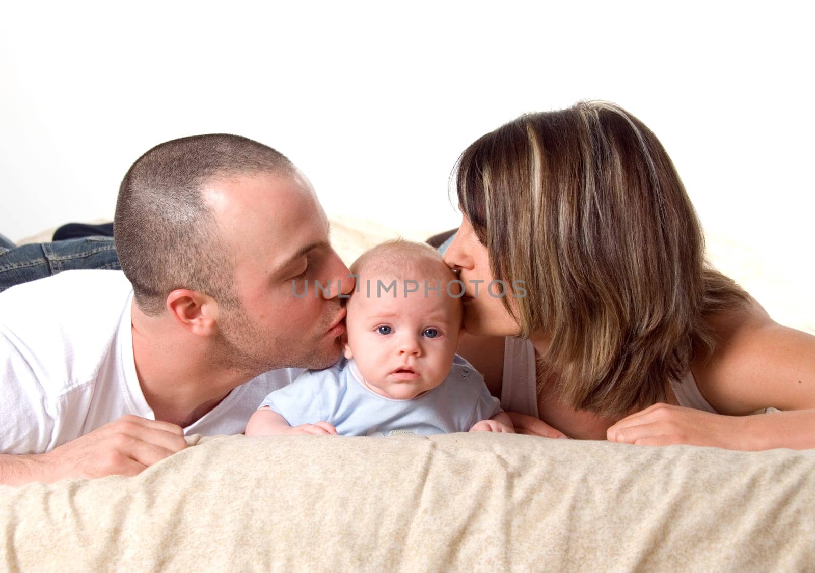 mom dad and the new born baby lying on the bed