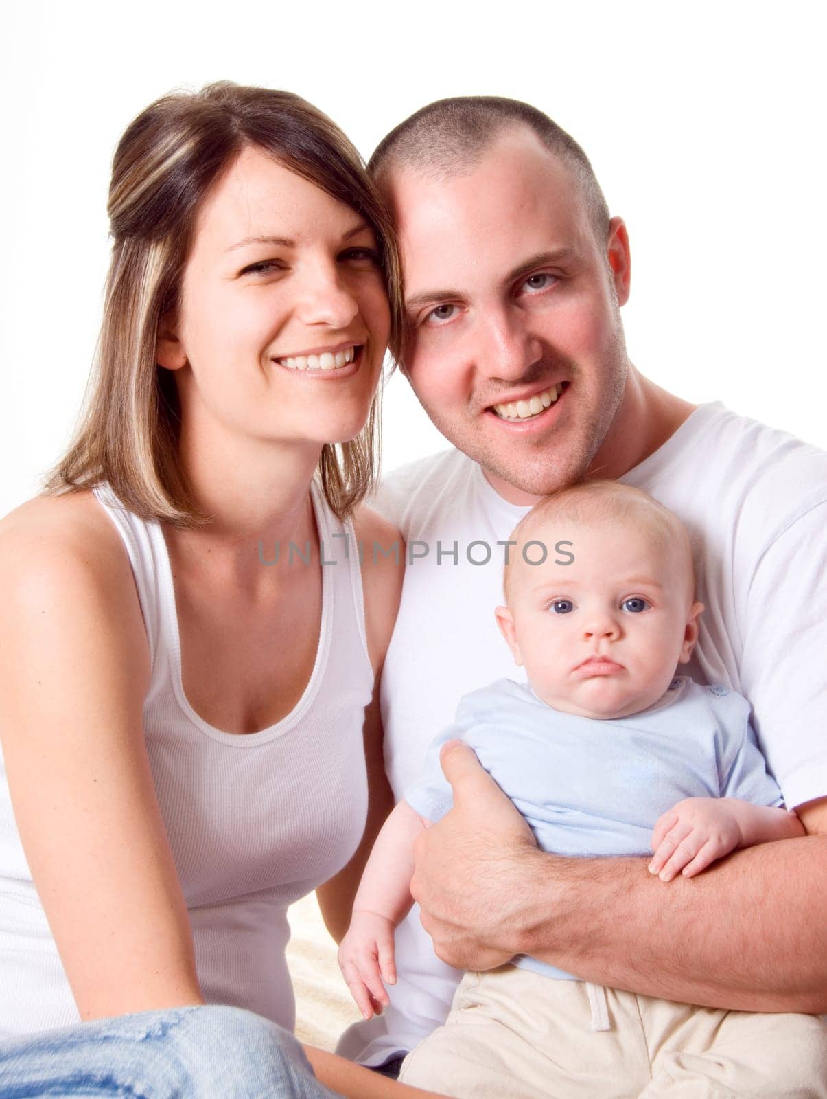 mom dad and the new born baby sitting on the bed
