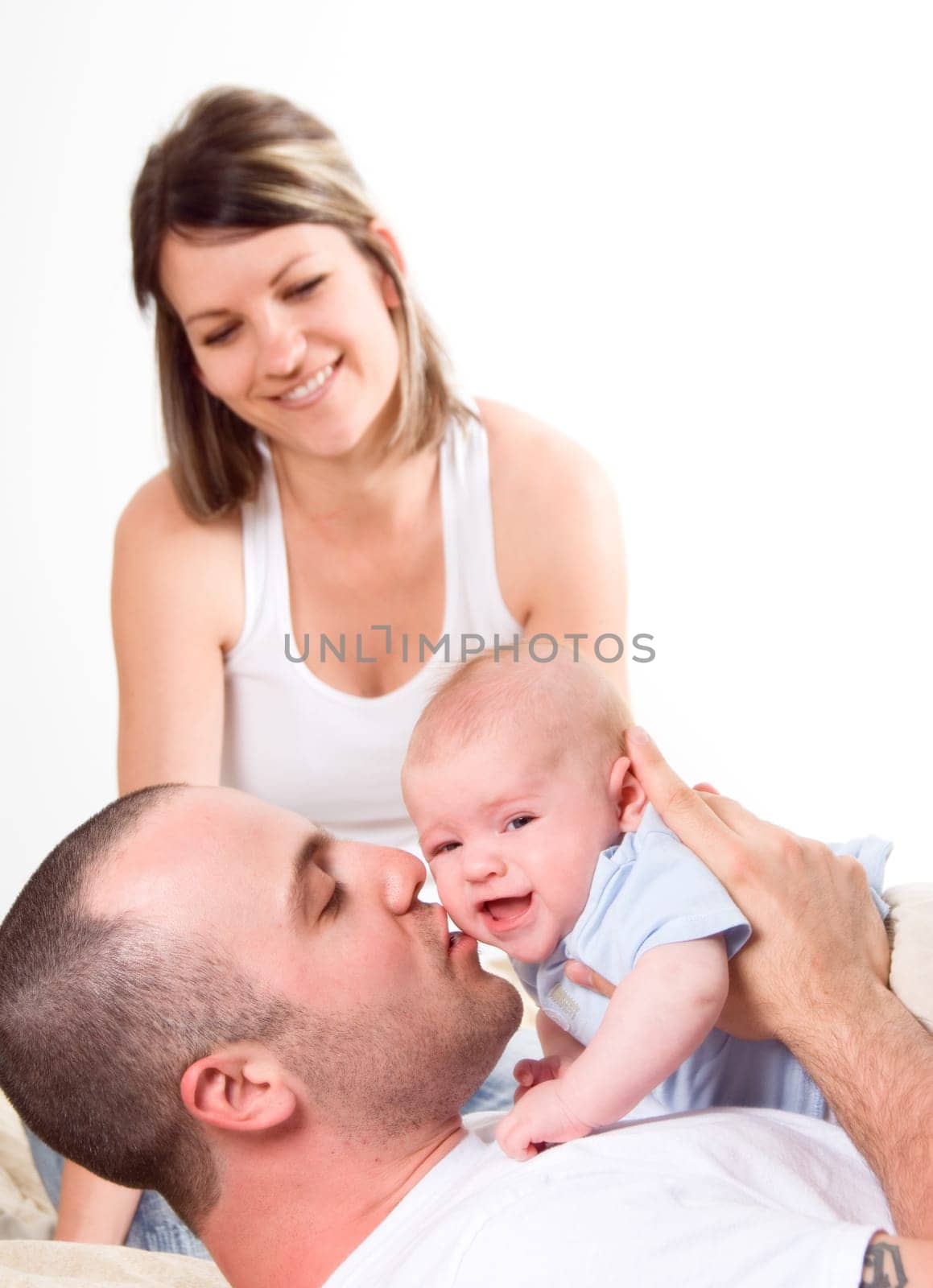 mom dad and the new born baby sitting on the bed