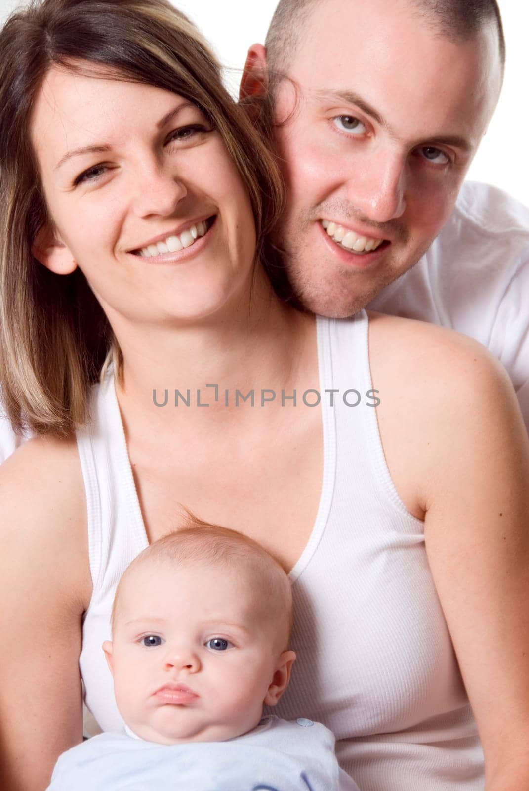 mom dad and the new born baby sitting on the bed