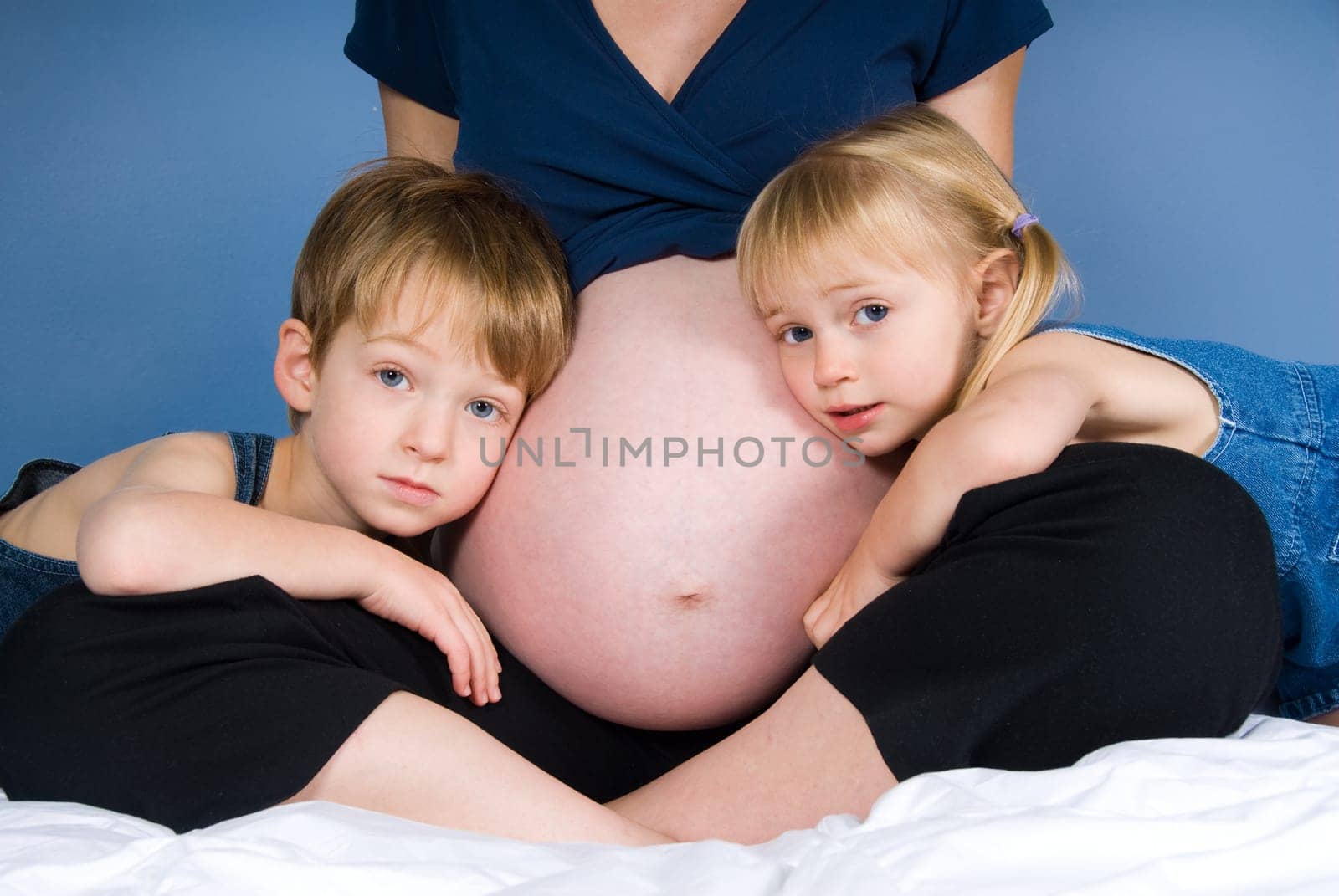 two cute kids with their pregnant mother