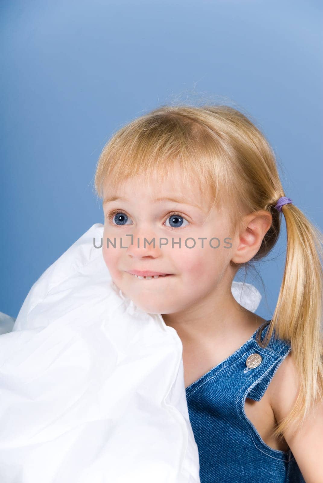 little cute blond girl on a blue wall