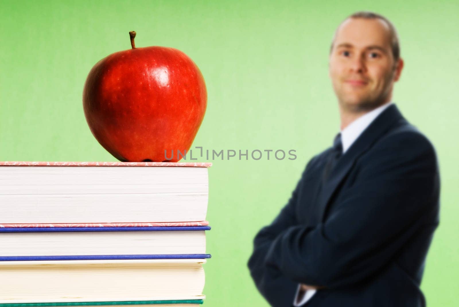 apple sitting on top of books in a classroom