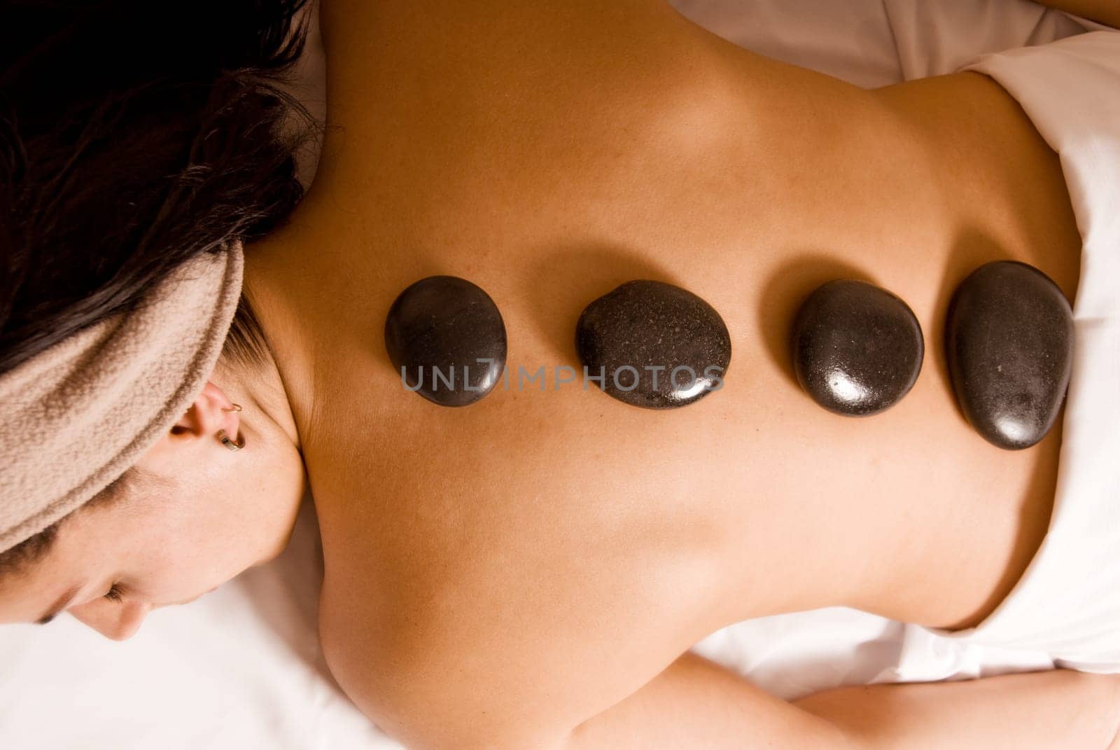 young woman getting a stone massage at a spa