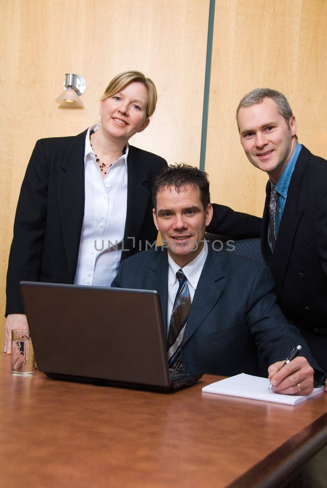 3 business people around a laptop in a meeting