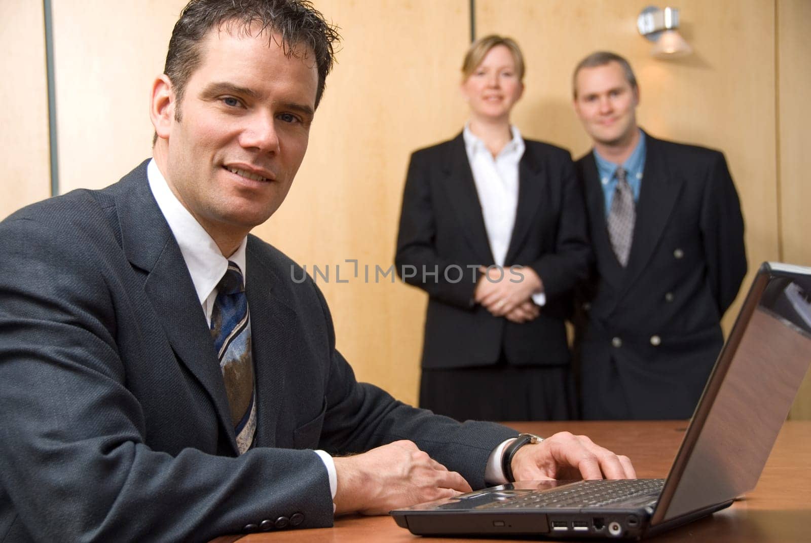 3 people looking at the camera with a laptop