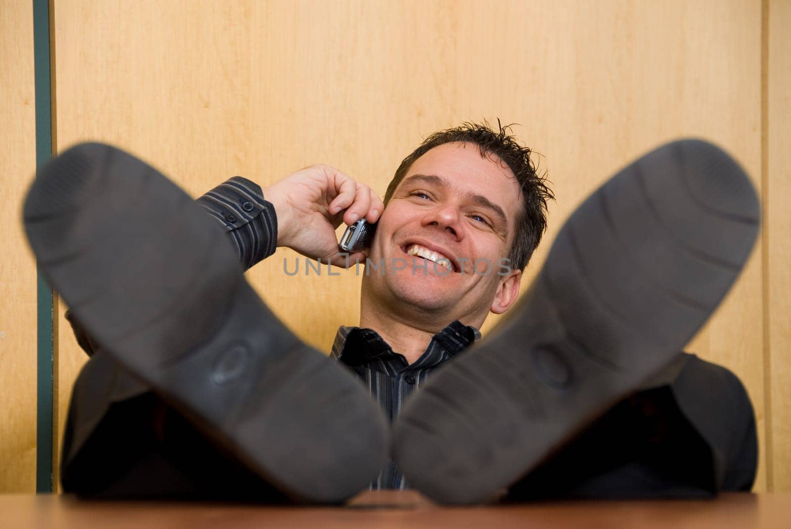 business man with his feet on the desk on the phone